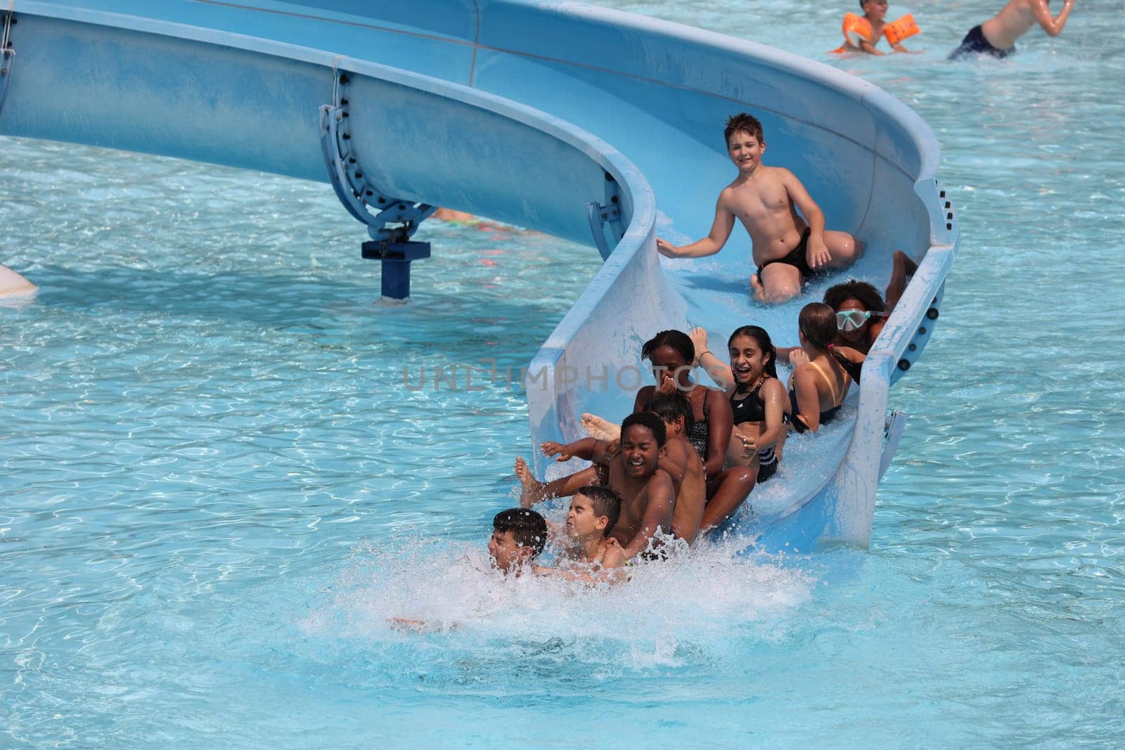 Theme picture summer -   The dog days are here - people crave to cool off at temperatures above 30 degrees Celsius,like here in the lido of Freiburg im Breisgau. And on the water slide,the whole group has a lot of fun