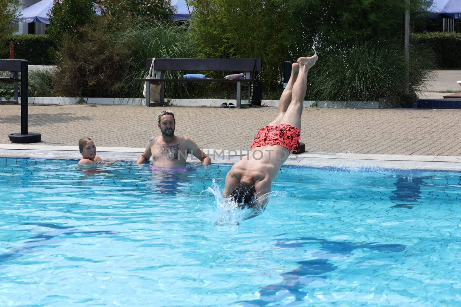 Theme picture summer -   The dog days are here - people crave to cool off at temperatures above 30 degrees Celsius,like here in the lido of Freiburg im Breisgau. Take a dip in the cool water