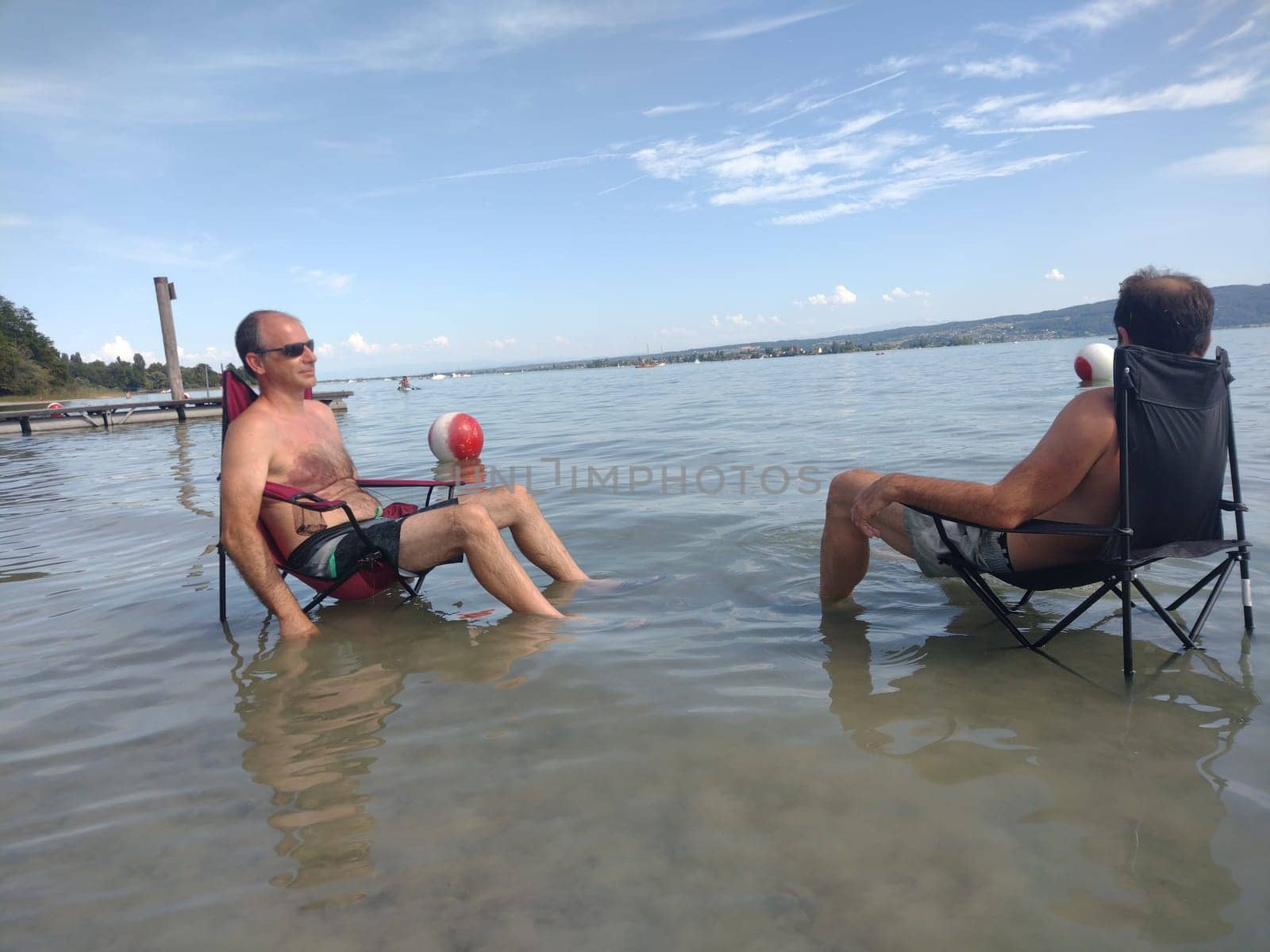 Theme picture Summer - Summer day at Lake Constance  This is how it can be endured on the hottest day of the year so far and not just cooling off for the feet: Despite the summer heat,these two men have positioned their sitting chair right next to Allensbach in Lake Constance and thus find the right cooling not only for their feet.  Young and old sought to cool off on a boat trip,an excursion with the Stand Up Paddle (SUP) or while swimming. The next few days are expected to remain hot in summer if thunderstorms are likely to occur