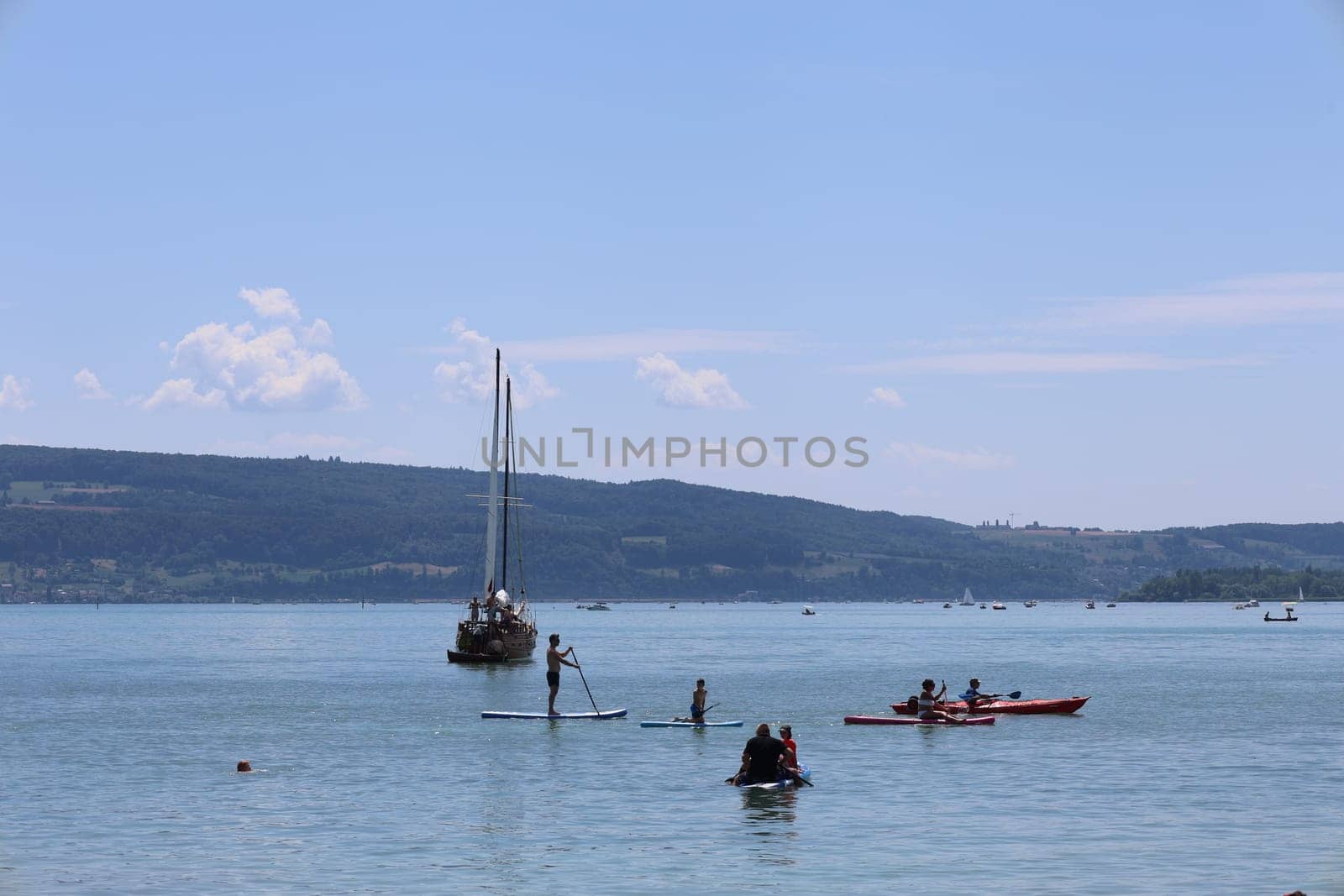 Theme picture Summer - Summer day at Lake Constance  Even at Lake Constance,as here near Allensbach,people were drawn to or to the water on this hot weekend. Young and old sought to cool off on a boat trip,an excursion with the Stand Up Paddle (SUP) or while swimming. The next few days are expected to remain hot in summer if thunderstorms are likely to occur