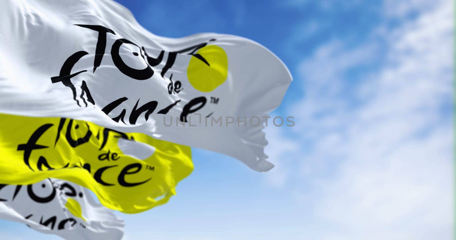 Paris, FR, June 26 2023: Tour de France flags waving. Most important international cycling event of the year. Illustrative editorial 3d illustration render