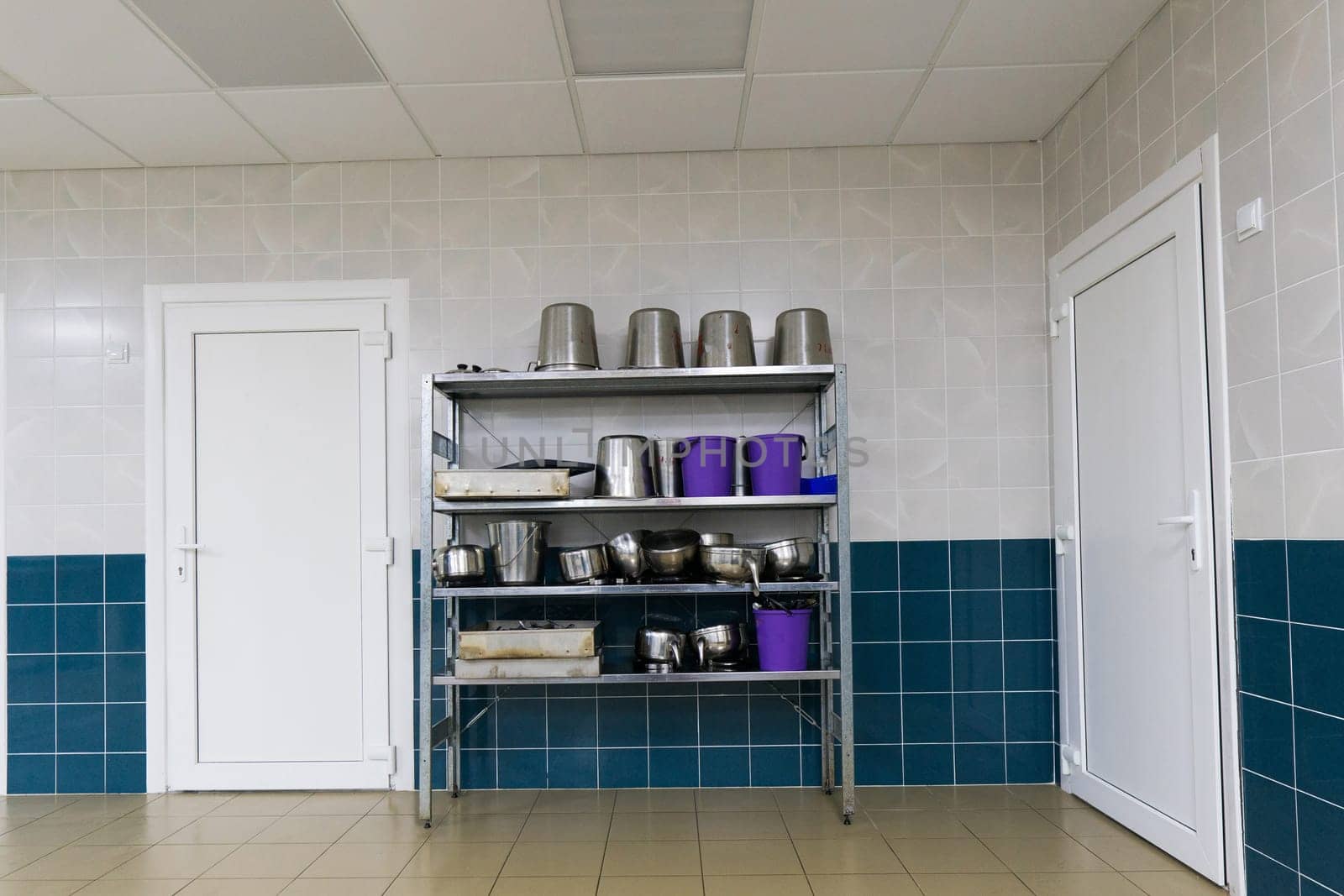 Industrial kitchen in school restaurant with professional equipment and pans