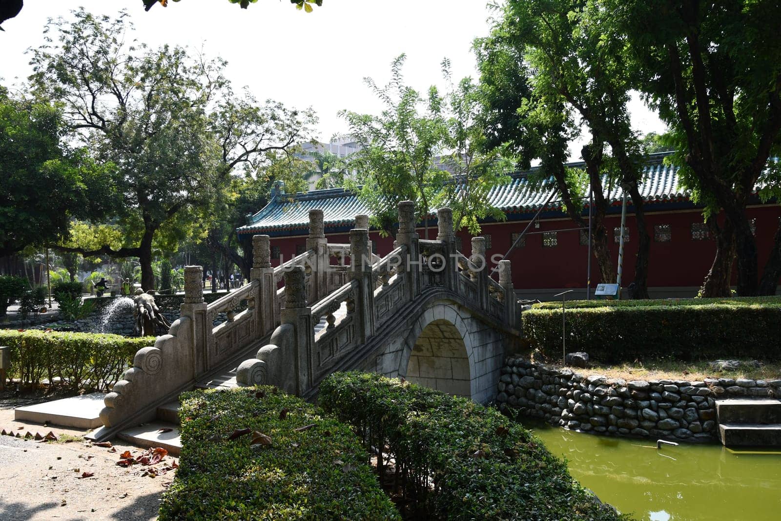 Bridge over a ditch with green water around the Buddhist monastery in Taiwan