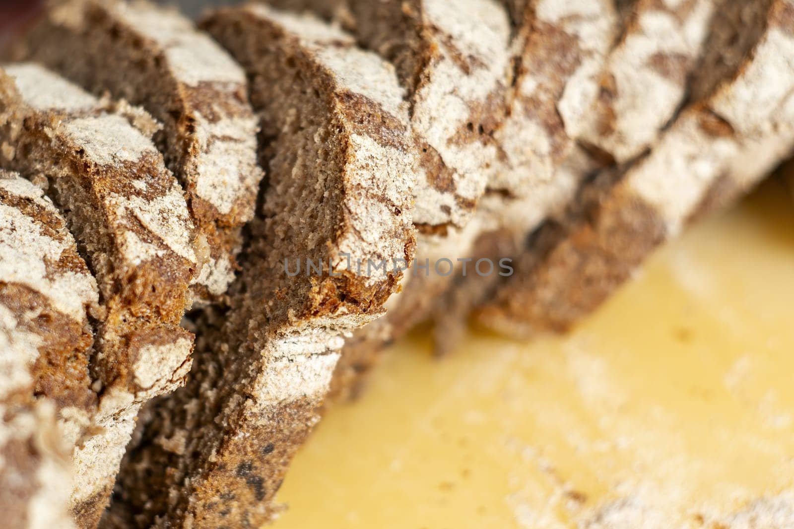 close-up view of some freshly cut slices of whole grain rye bread. Whole grain rye bread is made from all parts of the rye grain and has potential health benefits.