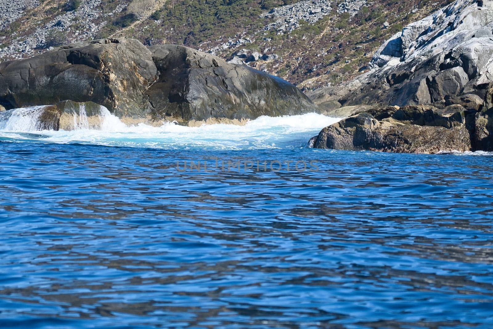 norway on the fjord, spray on rocks. Water splashes on the stones. Coastal landscape in Scandinavia. Landscape photo from the north