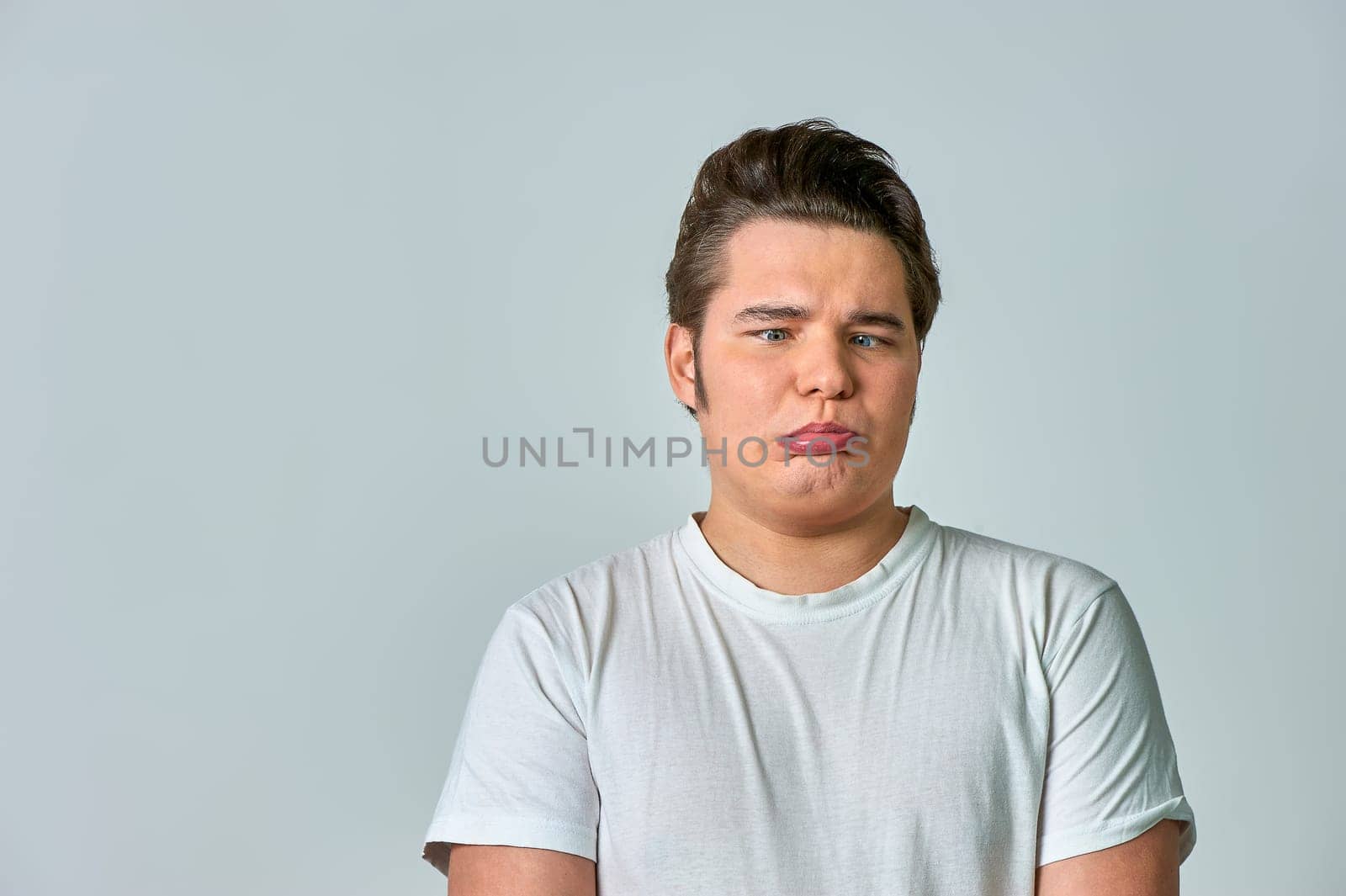 the man on the gray background brought his eyes together. High quality photo