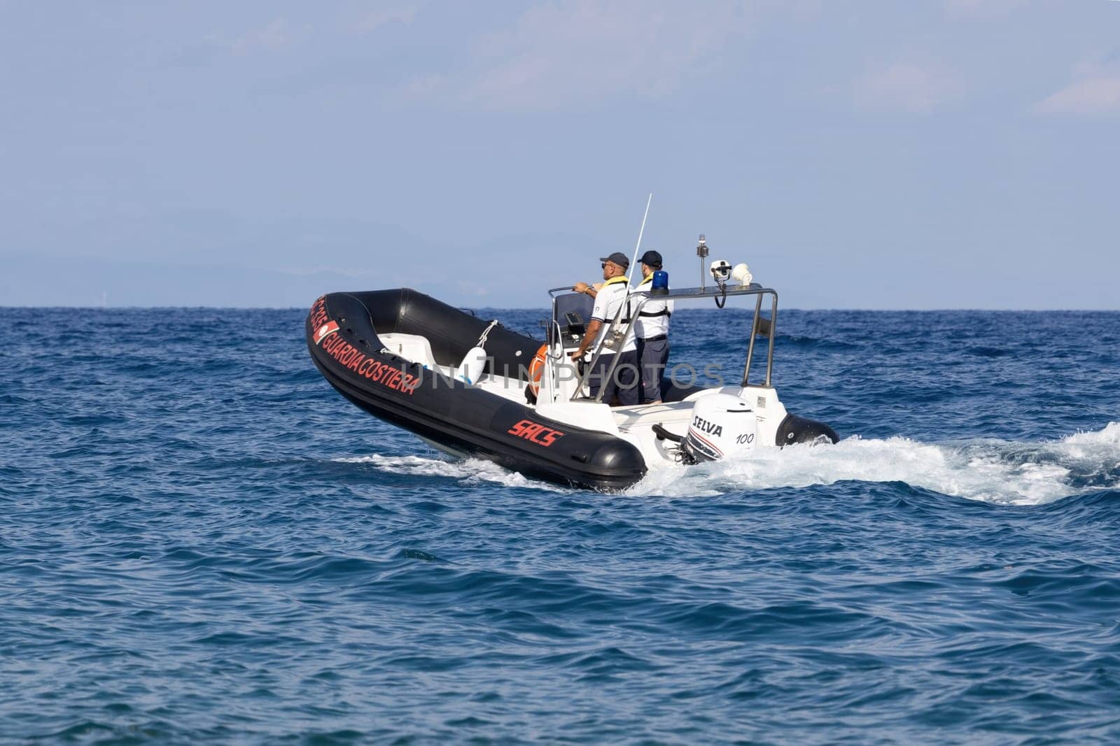FIUMEFREDDO DI SICILIA, SICILY, ITALY - AUGUST 12, 2022  Coast Guard patrolling with a lifeboat near the coast of Sicily in the Mediterranean Sea