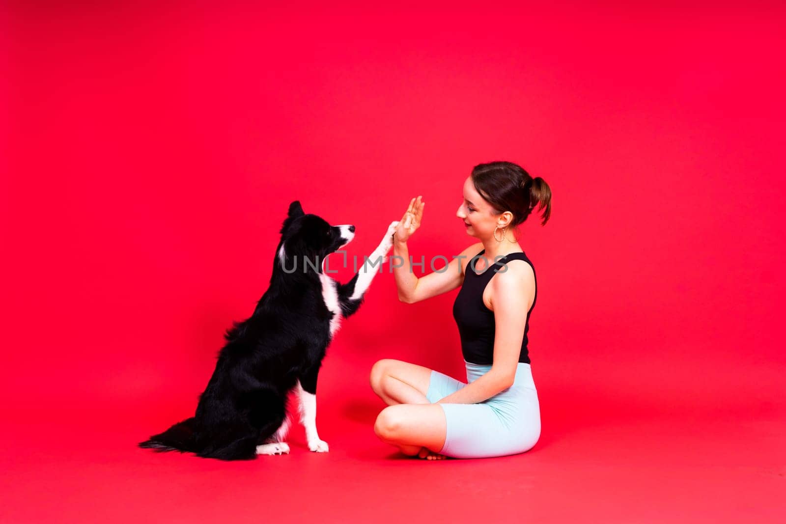 Woman walks and getting exercise for both herself and her border collie dog.
