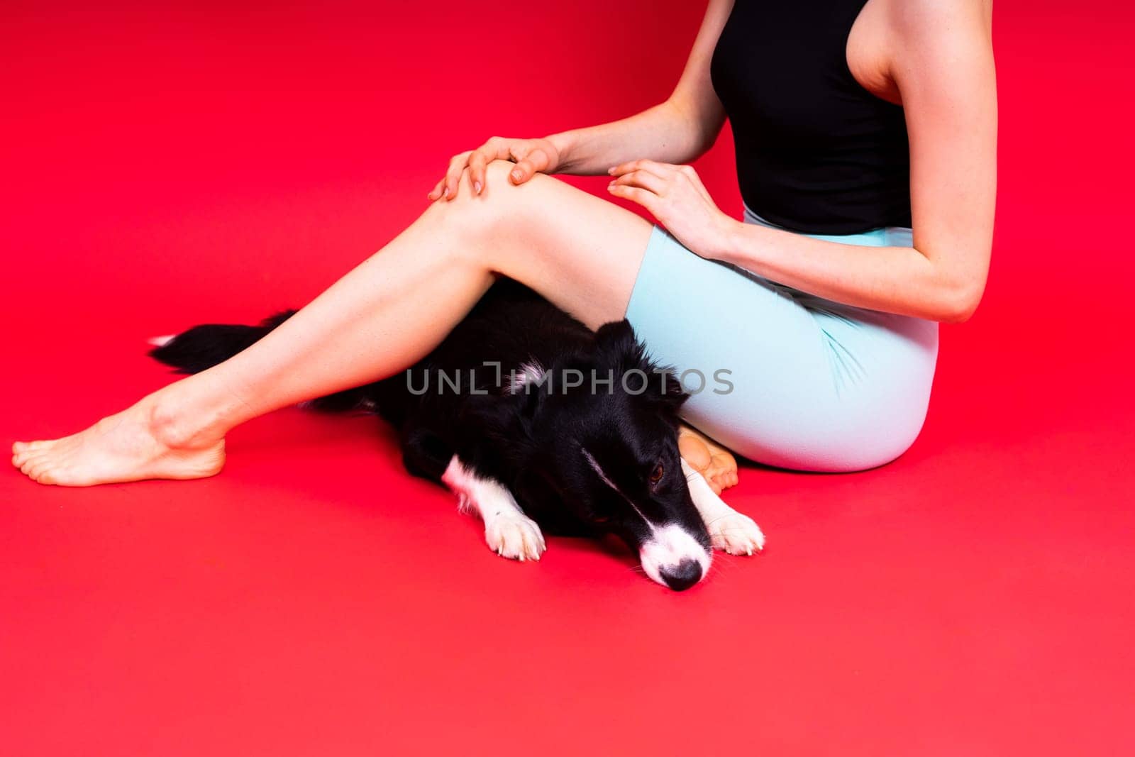 Woman walks and getting exercise for both herself and her border collie dog.
