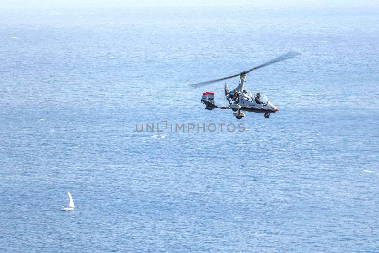 Taormina, Sicily, Italy - August 7, 2022 Leisure flight with Autogiro on the coast of Taormina in the Mediterranean Sea