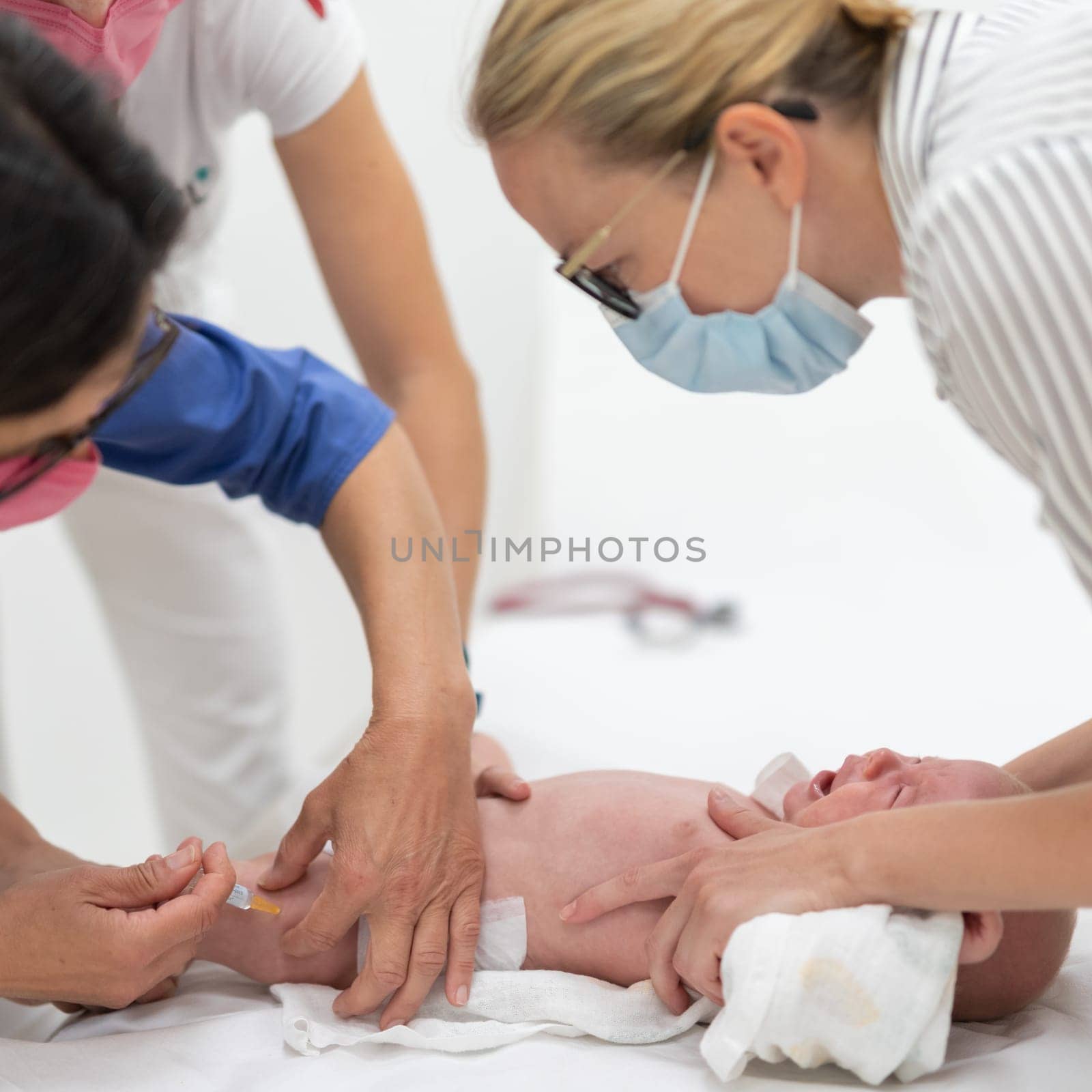 Baby beeing vaccinated by pediatrician in presence of his mother. Preventive vaccination against Diphtheria, whooping cough, tetanus, hepatitis, haemophilus influenzae, pneumococcus, poliomyelitis.