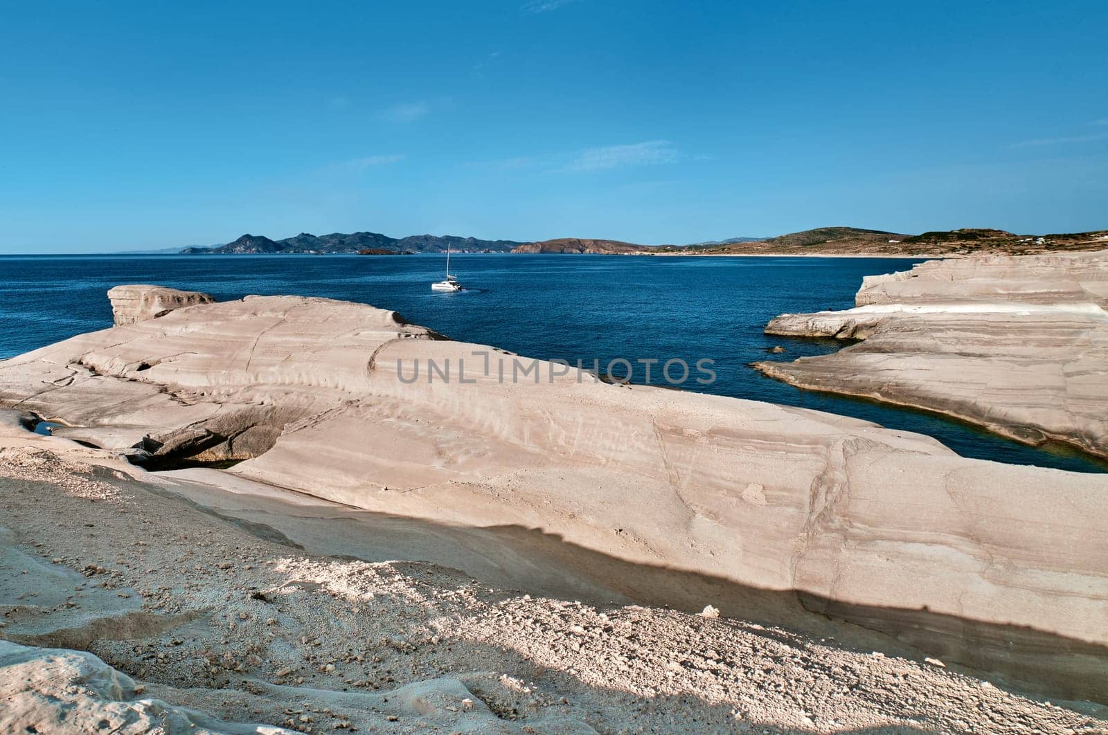 Beautiful landscape of white rocks of Sarakiniko beach, Aegean sea, Milos island , Greece. Empty cliffs, summer day sunshine, clear sea, blue waters, no people, beautiful landscape, fantastic rocks of tourist destination.