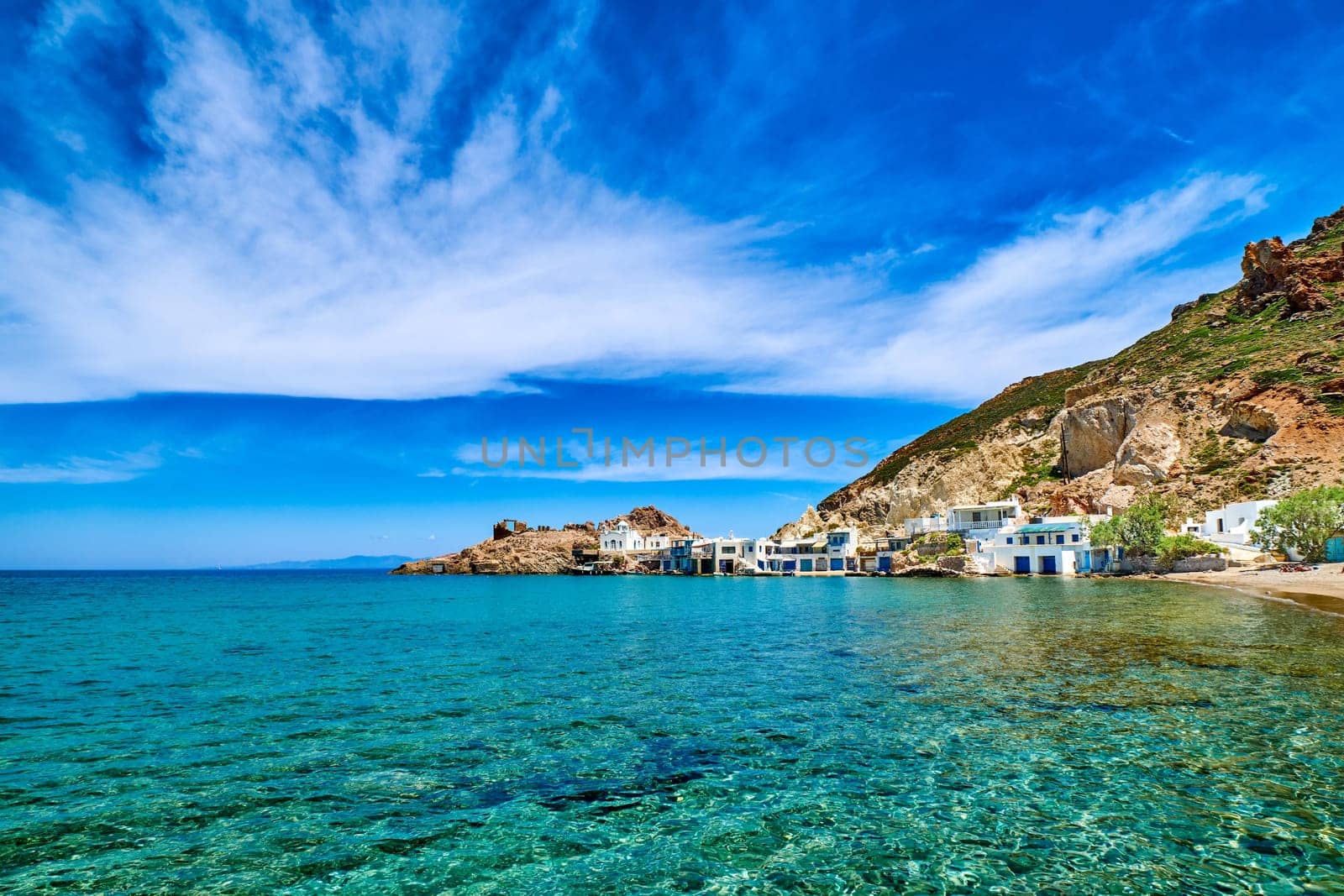 Beautiful small fishing village, traditional white fishermen houses and boat garages, turquoise clear sea water and blue sky. Firoporamos or Fyropotamos, Milos island, Cyclades, Greece. Perfect summer vacations site.
