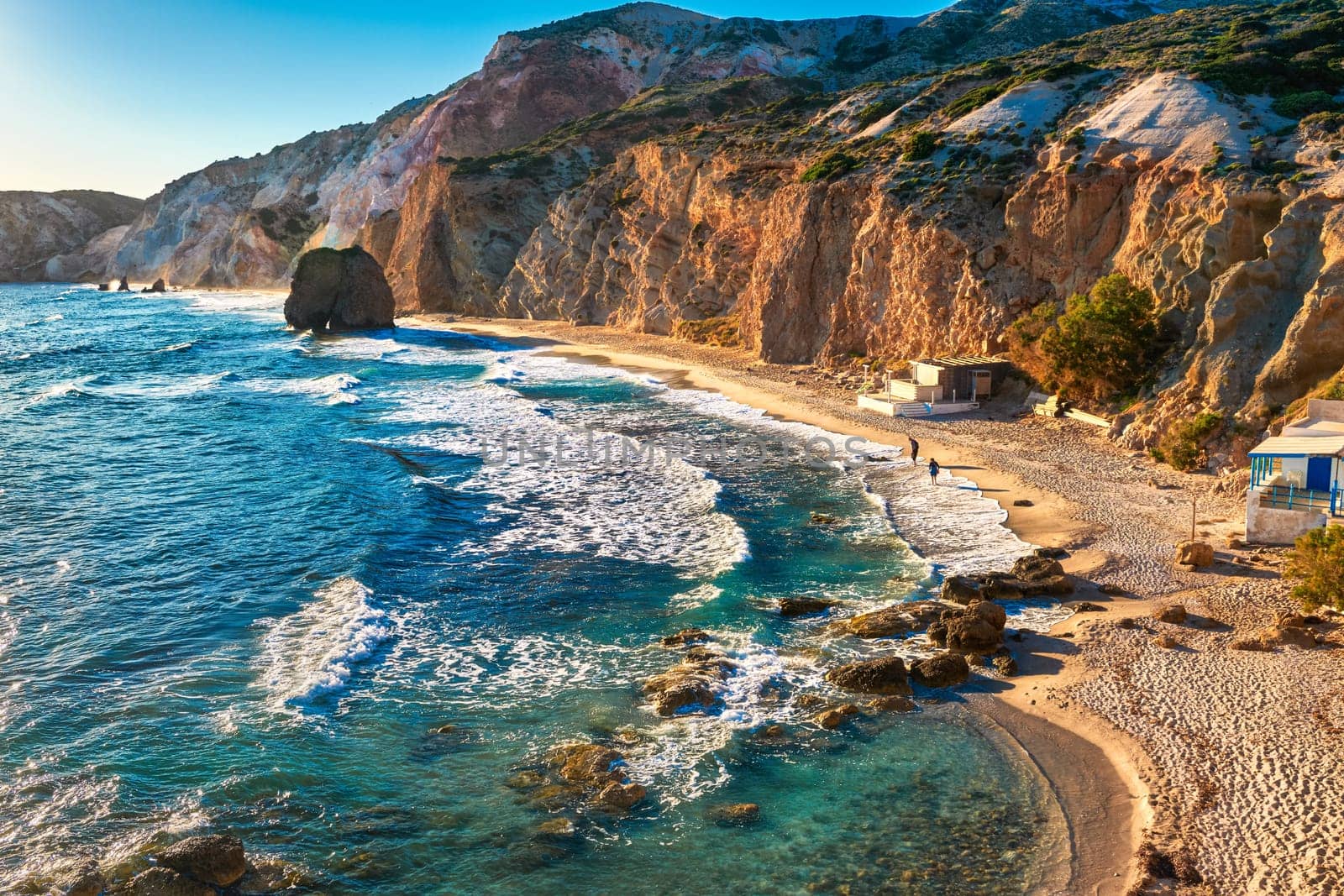 Beautiful sunset view of Fyriplaka beach, Milos island, Greece. Greek vacations, Aegean sea, high rocky landscape, azure waters, sandy beach, unique location of traditional tourist destination,