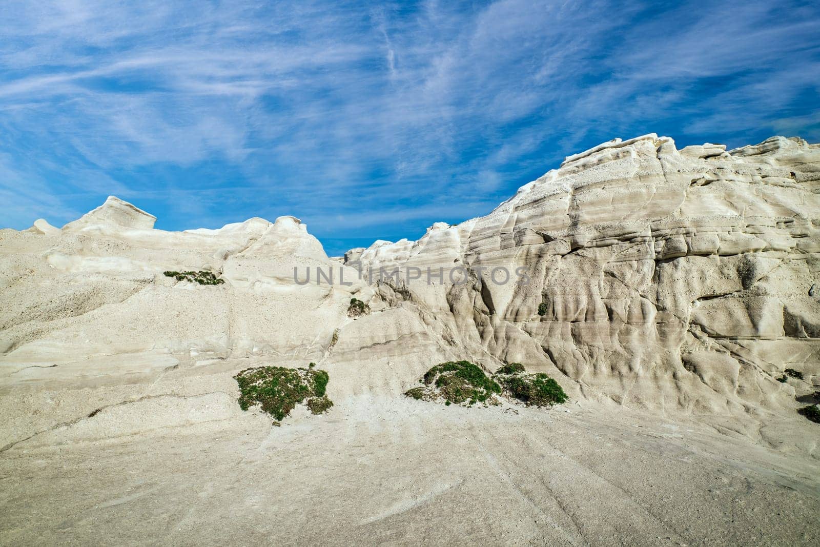 Beautiful white rocks of Sarakiniko beach, Aegean sea, Milos island , Greece. No people, empty cliffs, summer day sunshine, lunar landscape, fantastic rocks of tourist destination, deep blue sky, clouds.