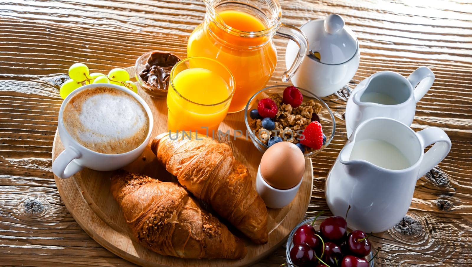 Breakfast served with coffee, orange juice, croissants and egg.