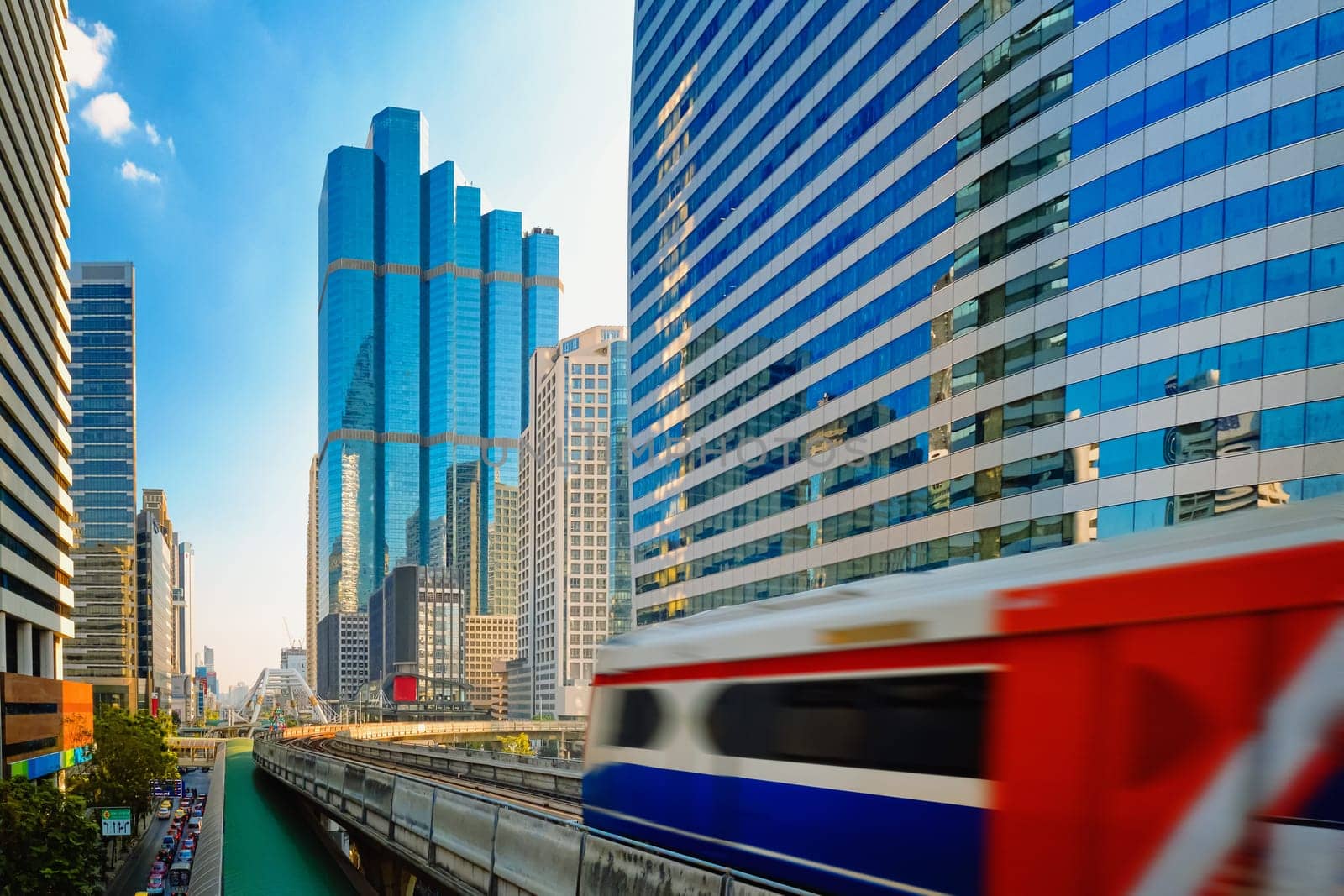 BTS Skytrain, light metro electric train, running fast in downtown, Bangkok, Thailand. Motion blur effect, modern office buildings, condominiums, business center, BTS rapid transit system, public transport, motion blur effect.
