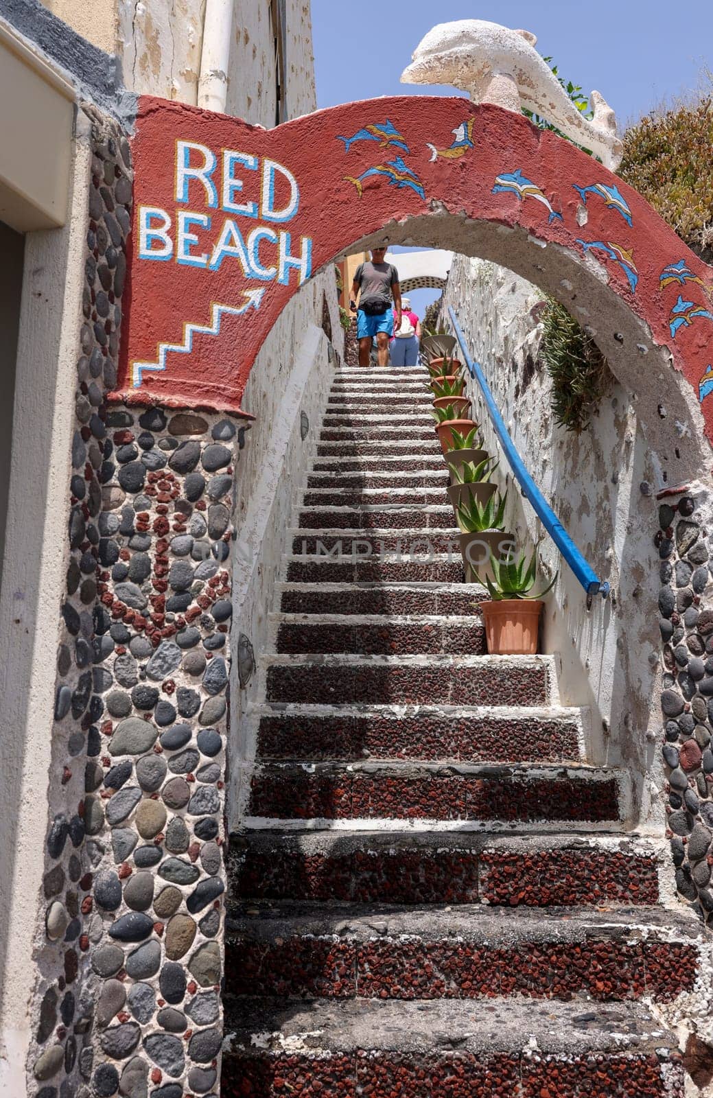 Santorini, Greece - July 01, 2021: Narrow stone steps in Red beach on the south coast of Santorini island, Cyclades. Greece