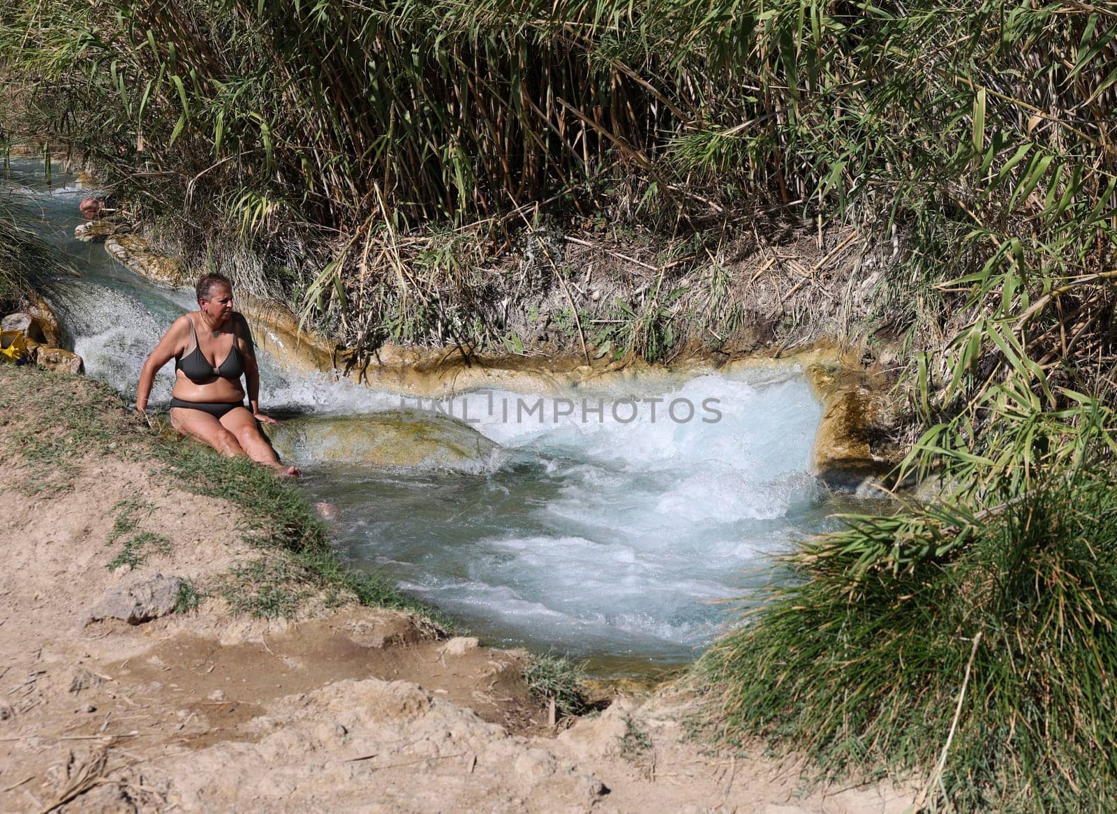 Saturnia, Italy - September 13, 2022:  People are bathing in the hot springs of Saturnia Therme, Saturnia, Tuscany, Italy