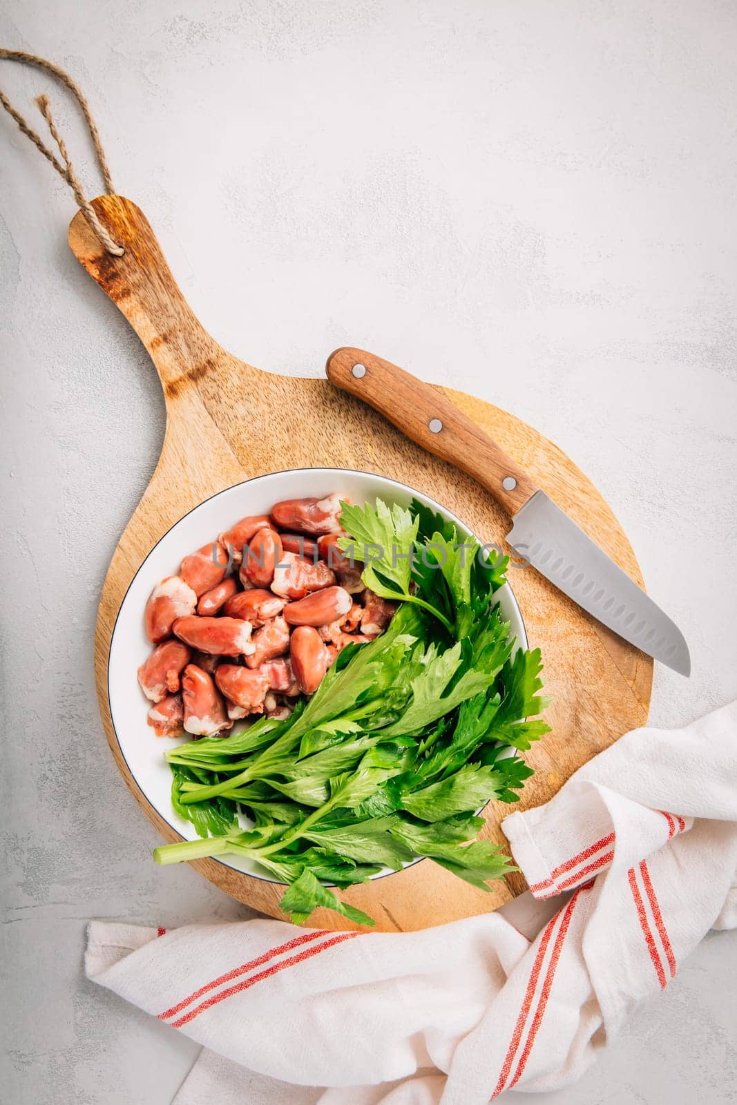 Fresh raw chicken hearts with celery leaves, reading for cooking