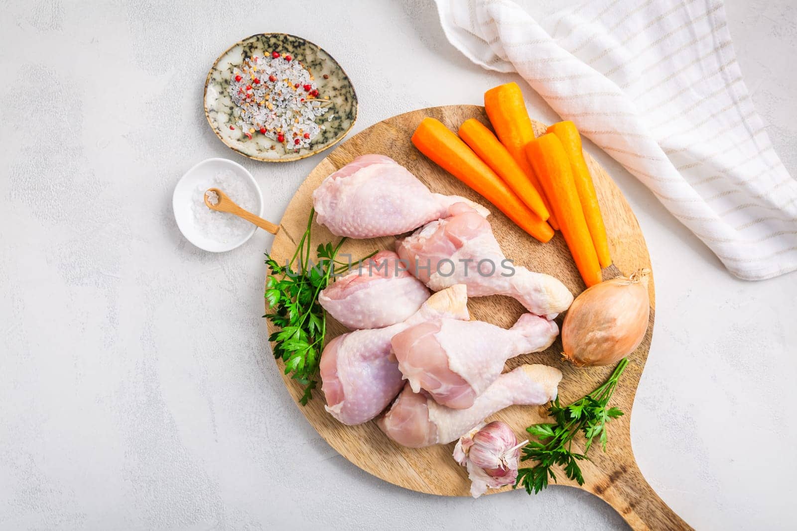 Raw chicken drumsticks with vegetables ans spices prepared for cooking
