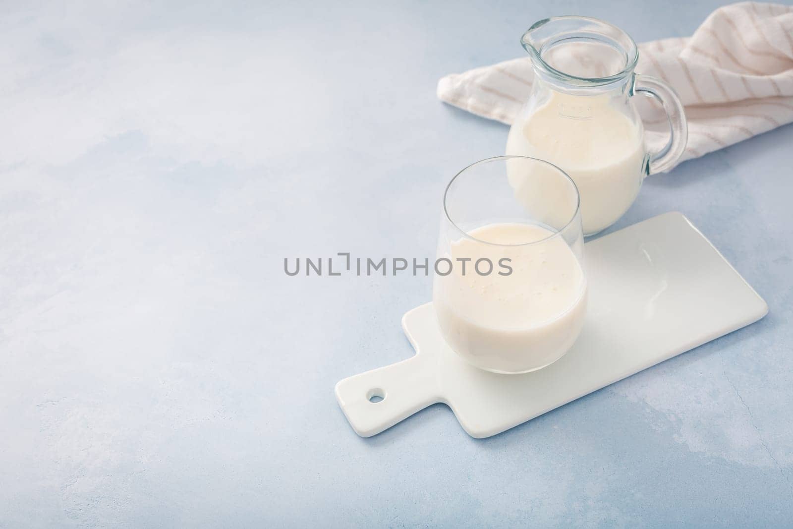Buttermilk, kefir, yogurt with probiotics, ayran in glass and jar. Probiotic cold fermented dairy drink. Trendy food and drink.