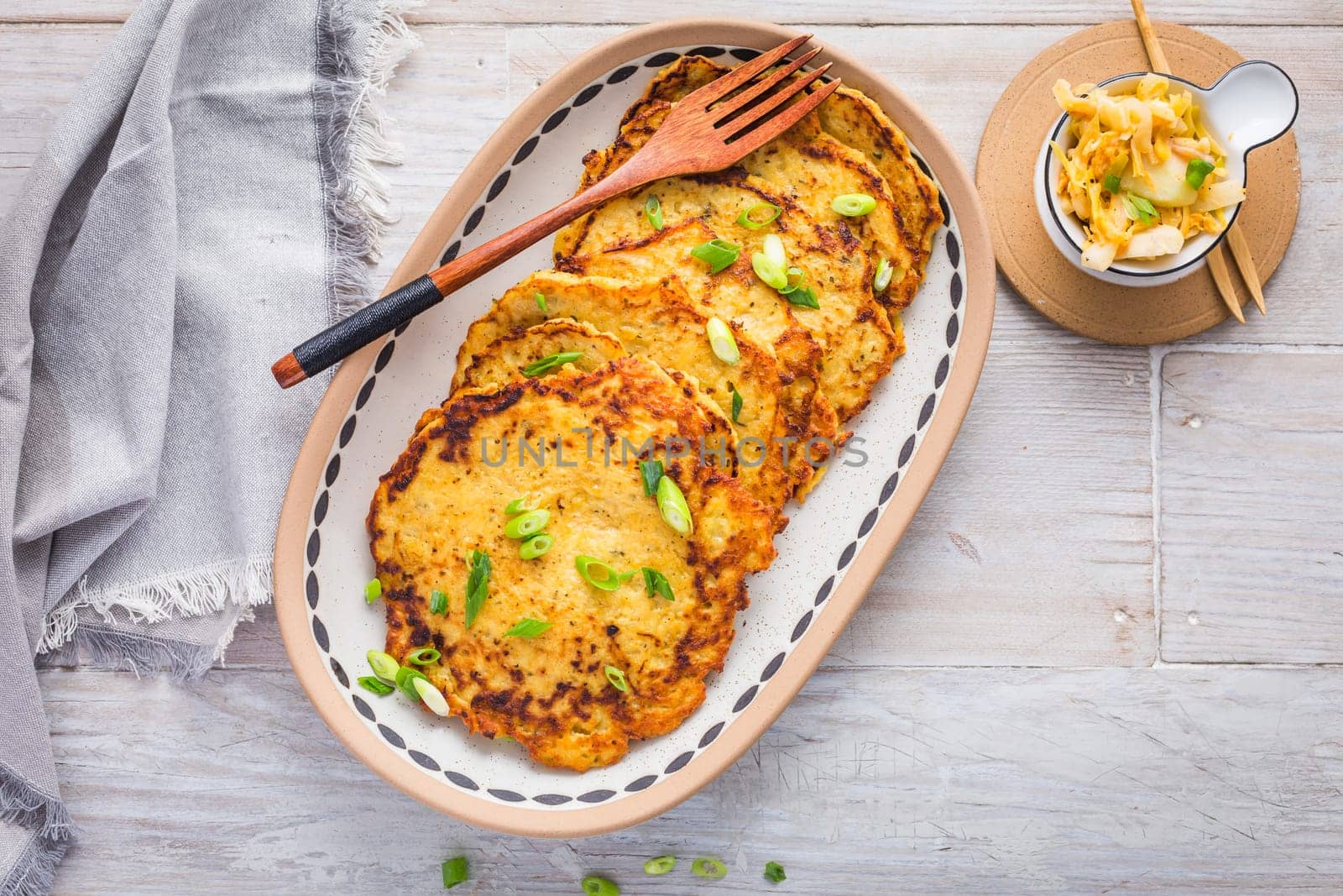 Homemade potato pancakes (Kartoffelpuffer) with cabbage salad and green onions