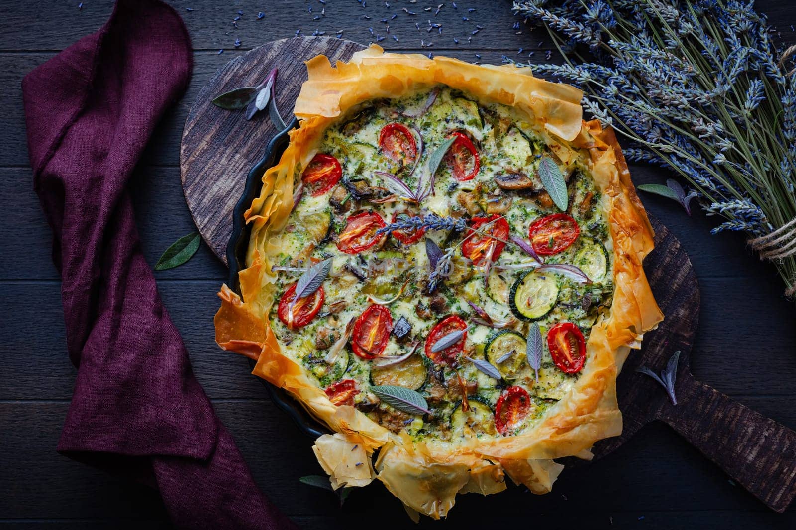 Delicious vegetarian summer quiche with zucchini, tomato, mushrooms, sage and lavender with phyllo pastry