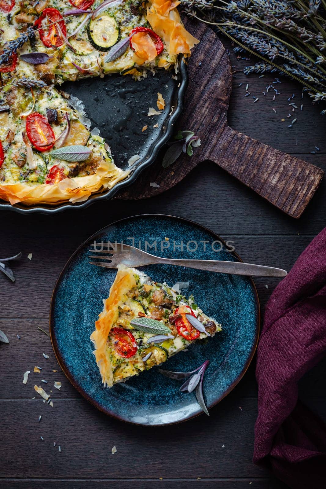 Delicious vegetarian summer quiche with zucchini, tomato, mushrooms, sage and lavender with phyllo pastry