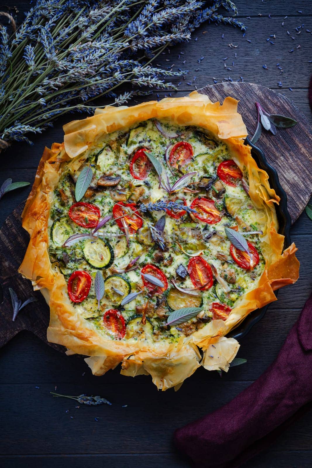 Delicious vegetarian summer quiche with zucchini, tomato, mushrooms, sage and lavender with phyllo pastry