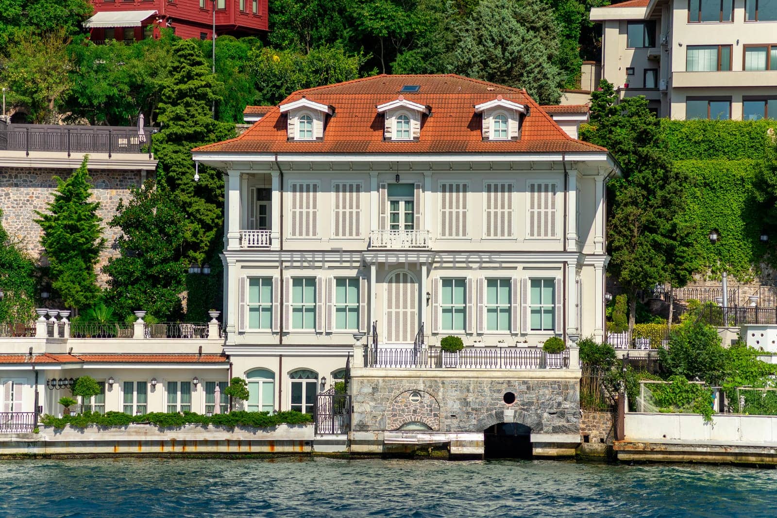 View from Bosphorus strait of the green mountains of the Asian side, with traditional houses and dense trees in a summer day, Istanbul, Turkey