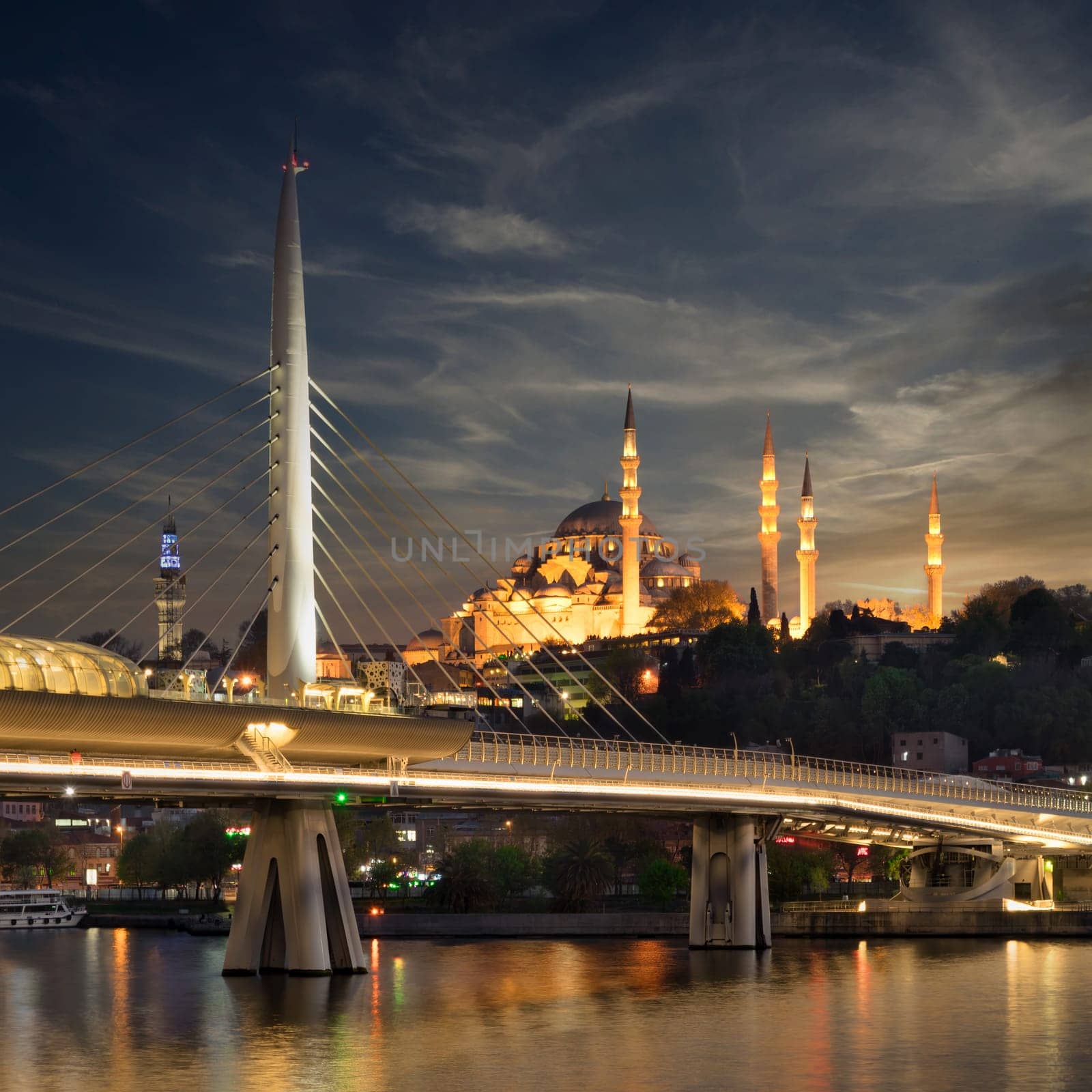Night shot of Golden Horn Metro Bridge, or Halic Bridge, overlapping Suleymaniye Mosque, Istanbul, Turkey