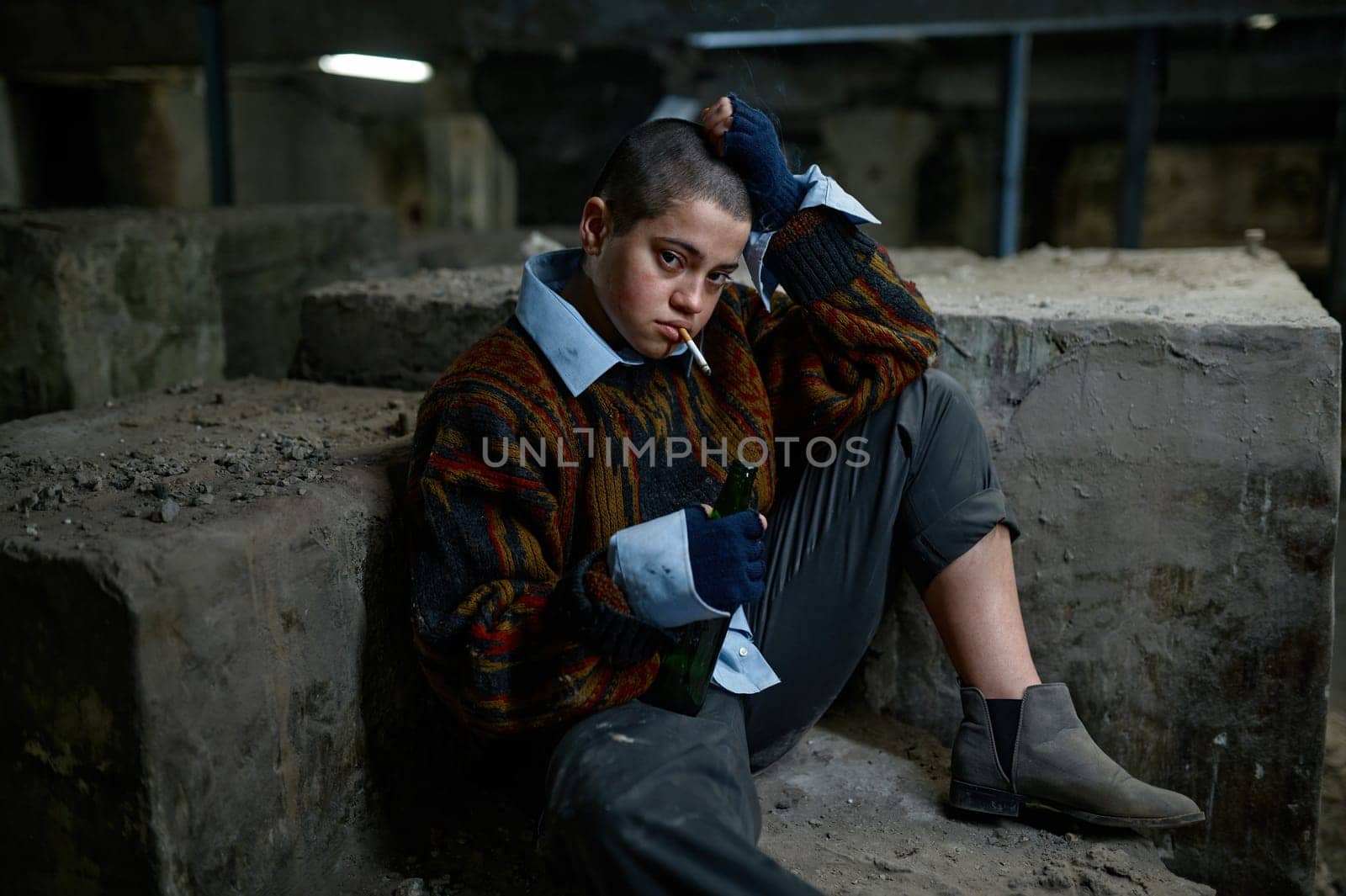 Portrait of young poor helpless woman smoking cigarette. Homelessness and refugee concept