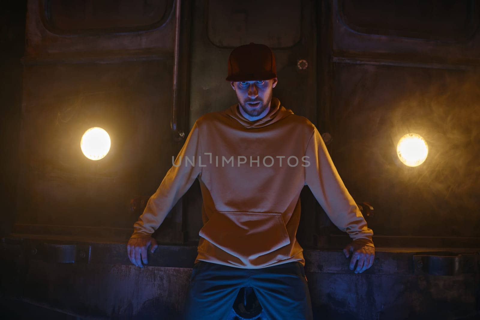 Portrait of breakdancer hipster b-boy preparing for performance standing at subway train. Contemporary freestyle dance performance concept