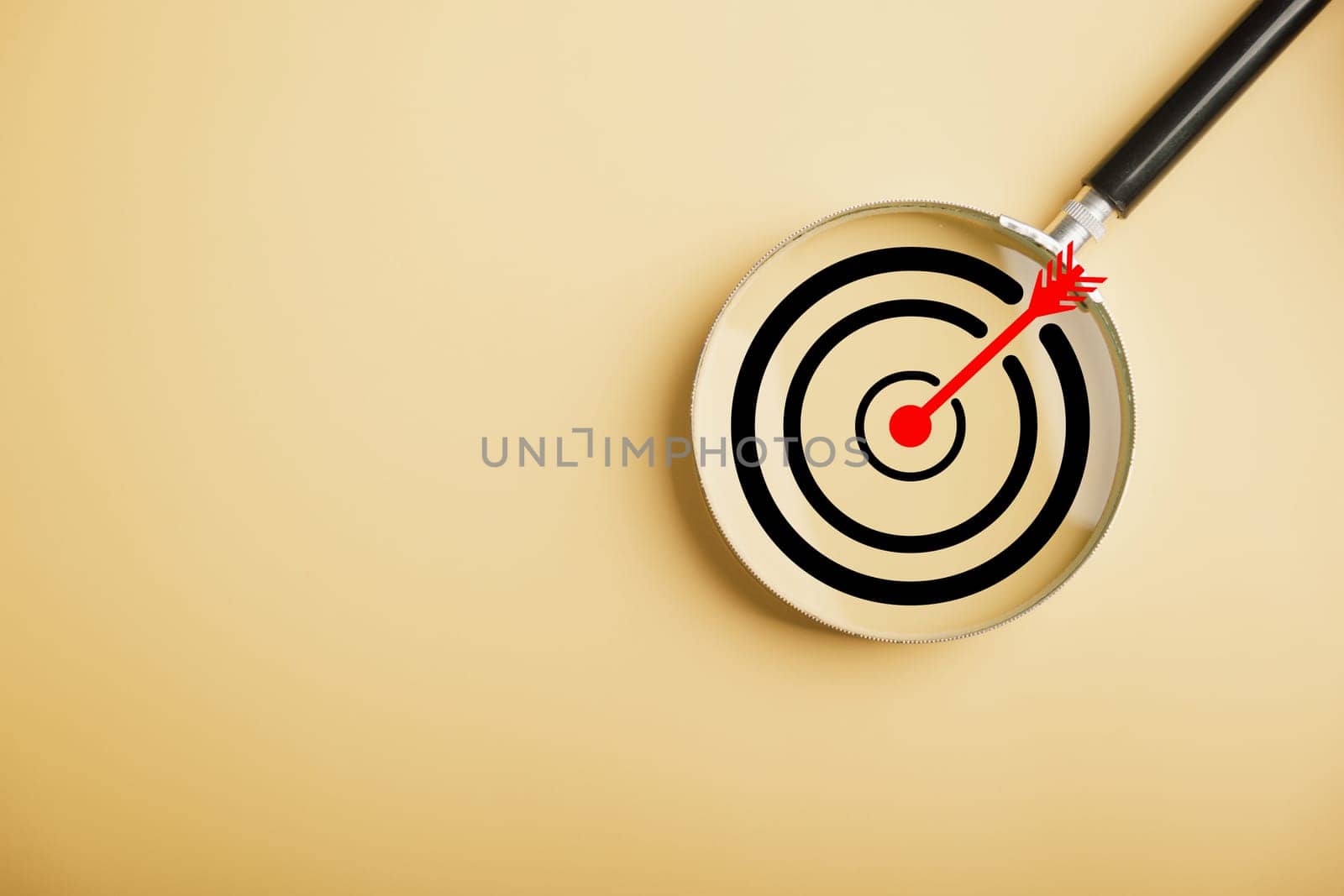 Magnifier glass highlights a target board, showcasing the precision in business objective focus. background and copy space, it conveys the significance of marketing strategies and corporate growth.