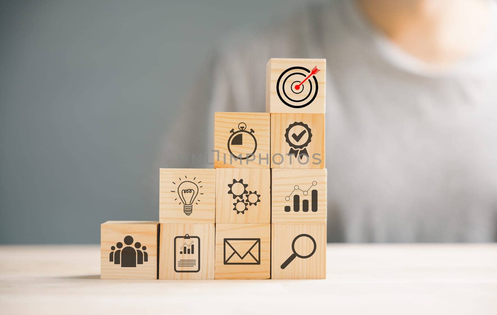 Wooden cube block step on a table with Action Plan, Goal, and Target icons. Success and business target concept. Project management and company strategy symbolize growth.