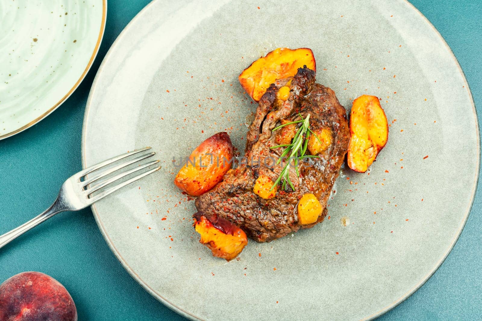Succulent beef steak with peach in fruit marinade. Close-up.