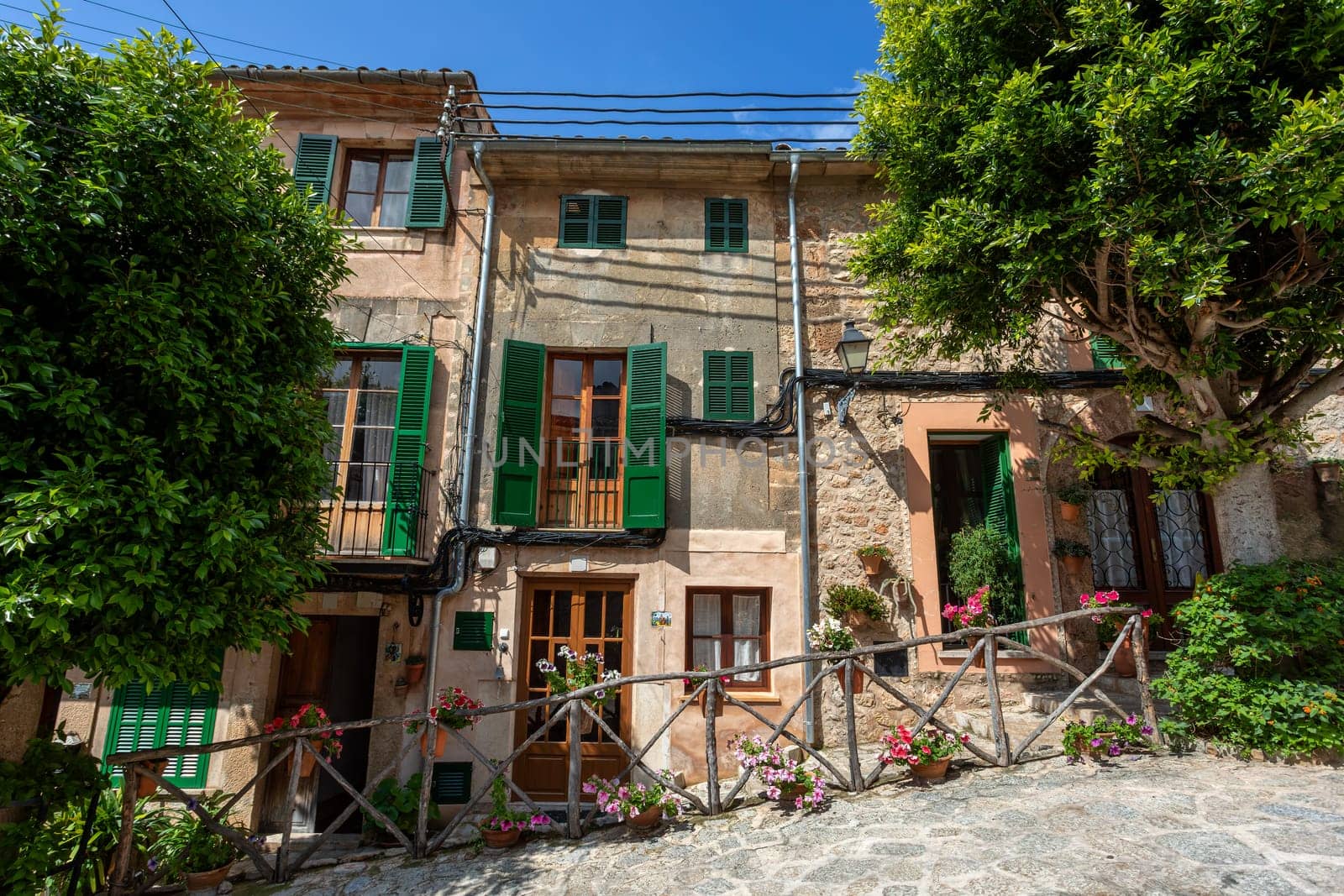 Narrow street in the Valldemossa with lots of ubiquitous flowers. Architectural treasures - Magic of Valldemossa's historic center and its Mediterranean architecture. Balearic Islands Mallorca Spain.