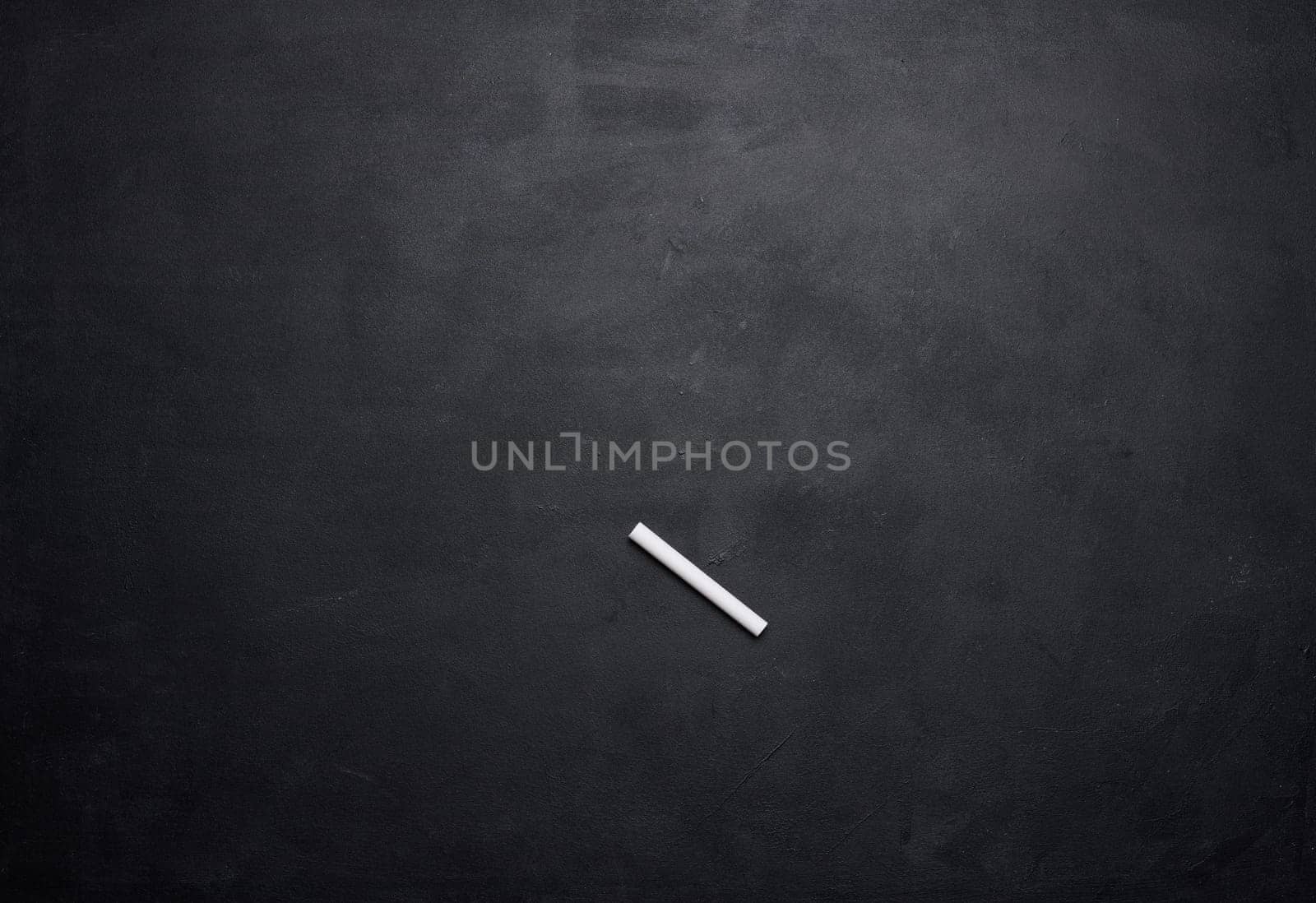 Empty black chalk board and white chalk stick