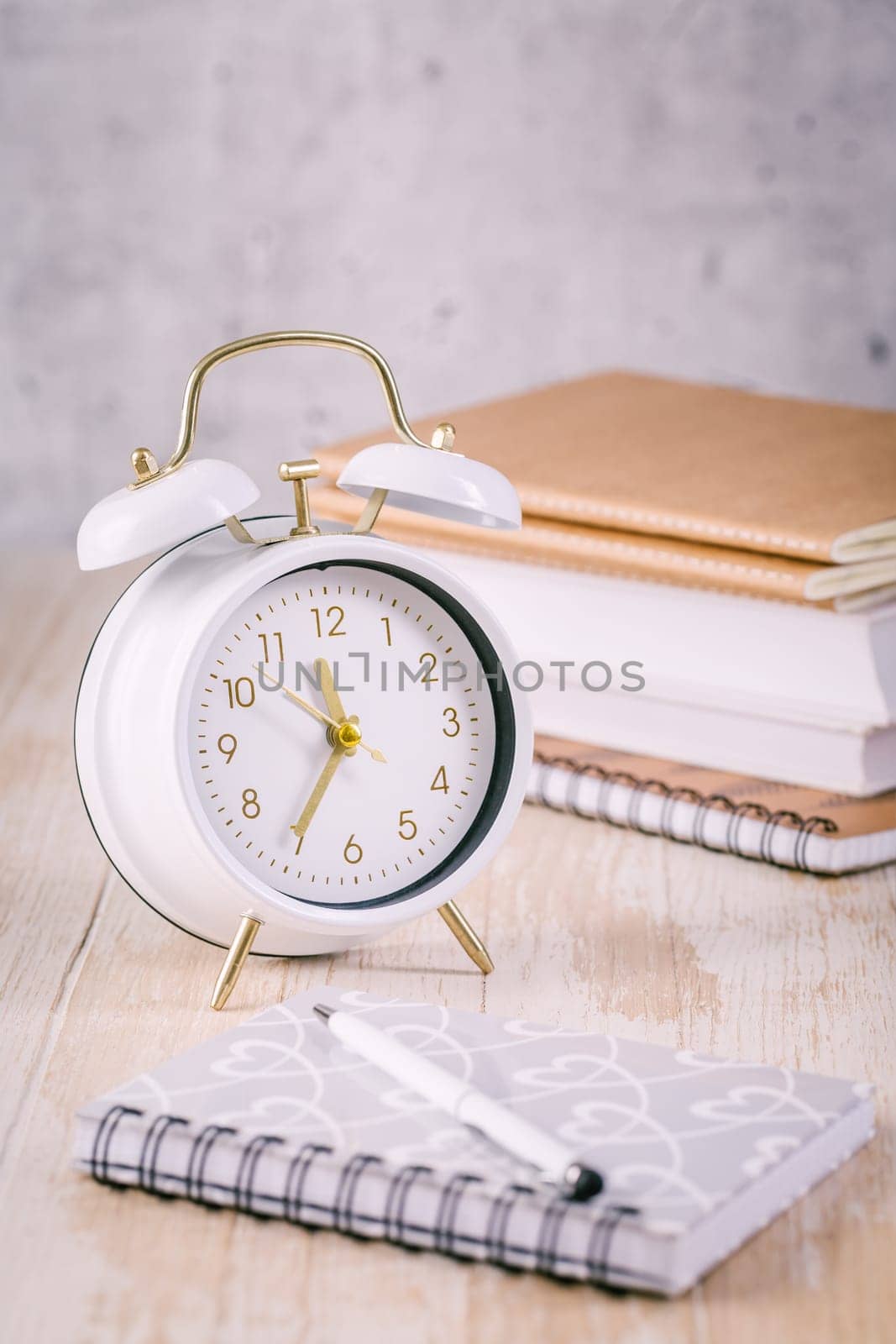 Alarm clock and books - time management and procrastination concept