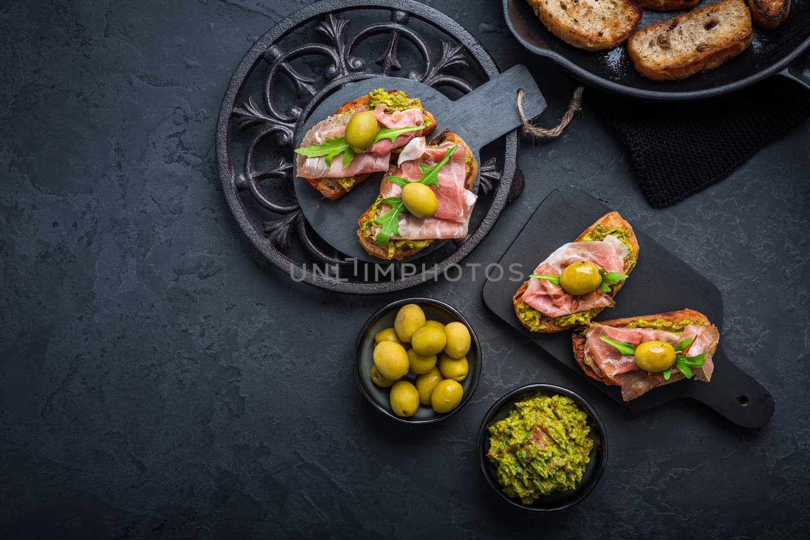 Delicious crostini with avocado spread and serrano or prosciutto ham