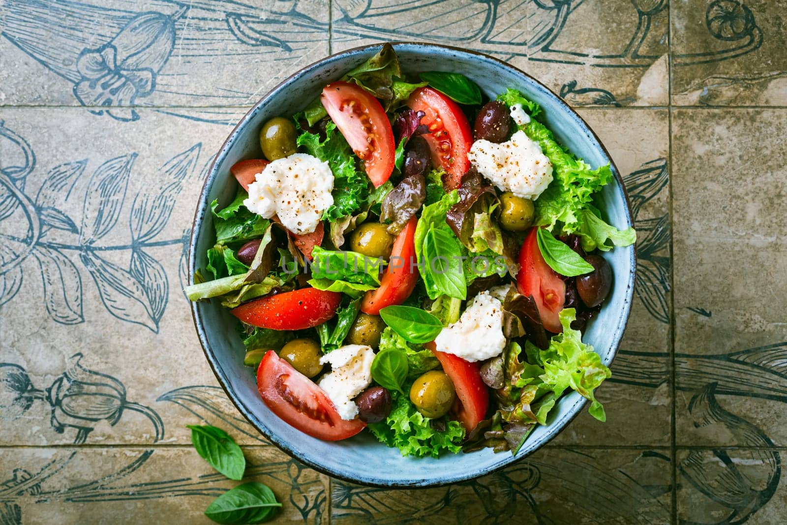 Burrata, Italian fresh cheese made from cream and milk of buffalo or cow. Burrata salad with tomatoes and salad mix. Healthy eating concept, keto diet salad