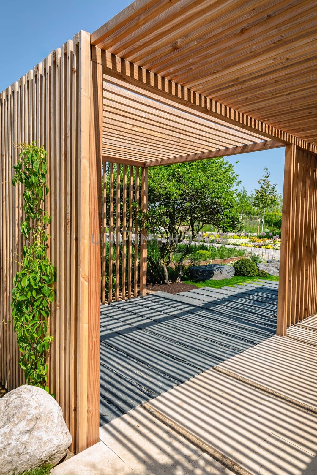 Modern wooden arbor. Modern wooden gazebo in courtyard, backyard. Urban gazebo, relaxing garden design.