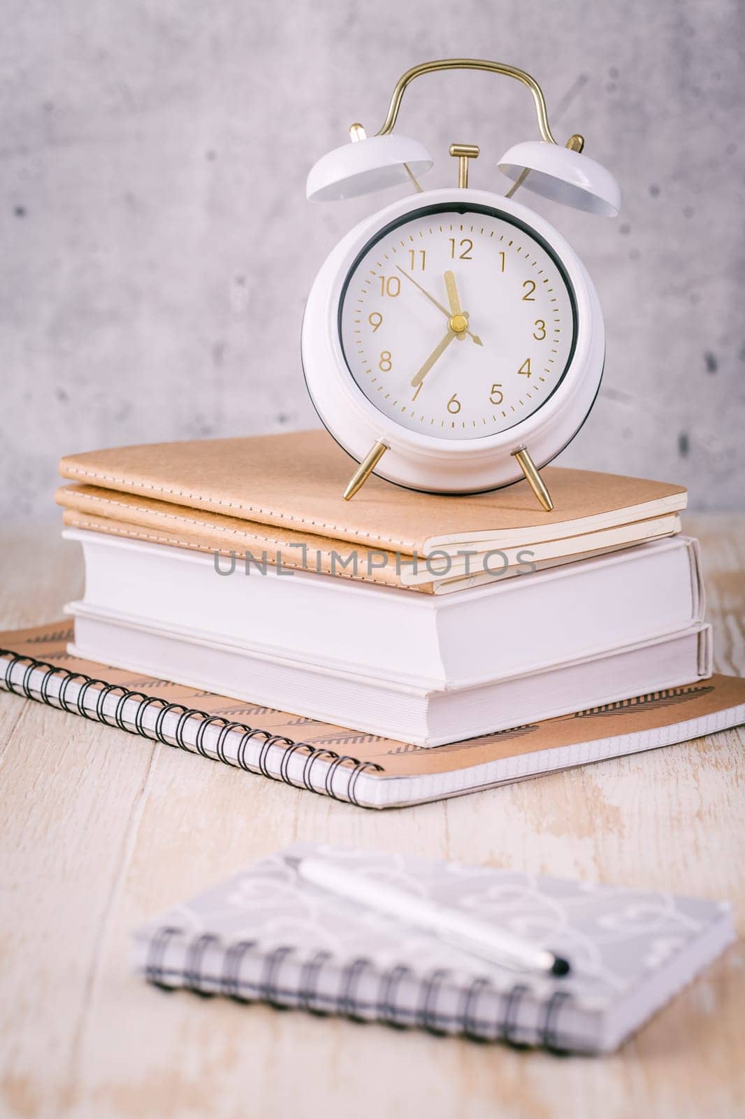 Alarm clock and books - time management and procrastination concept