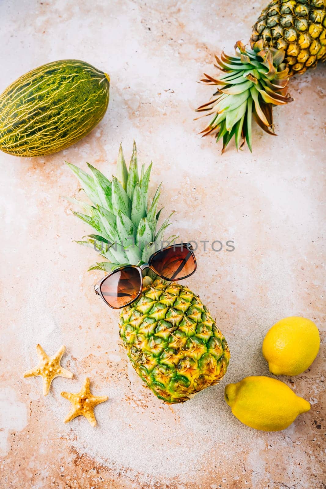 Summer concept - Pineapple hipster in sunglasses with melon and lemons, creative art fashionable vacation concept