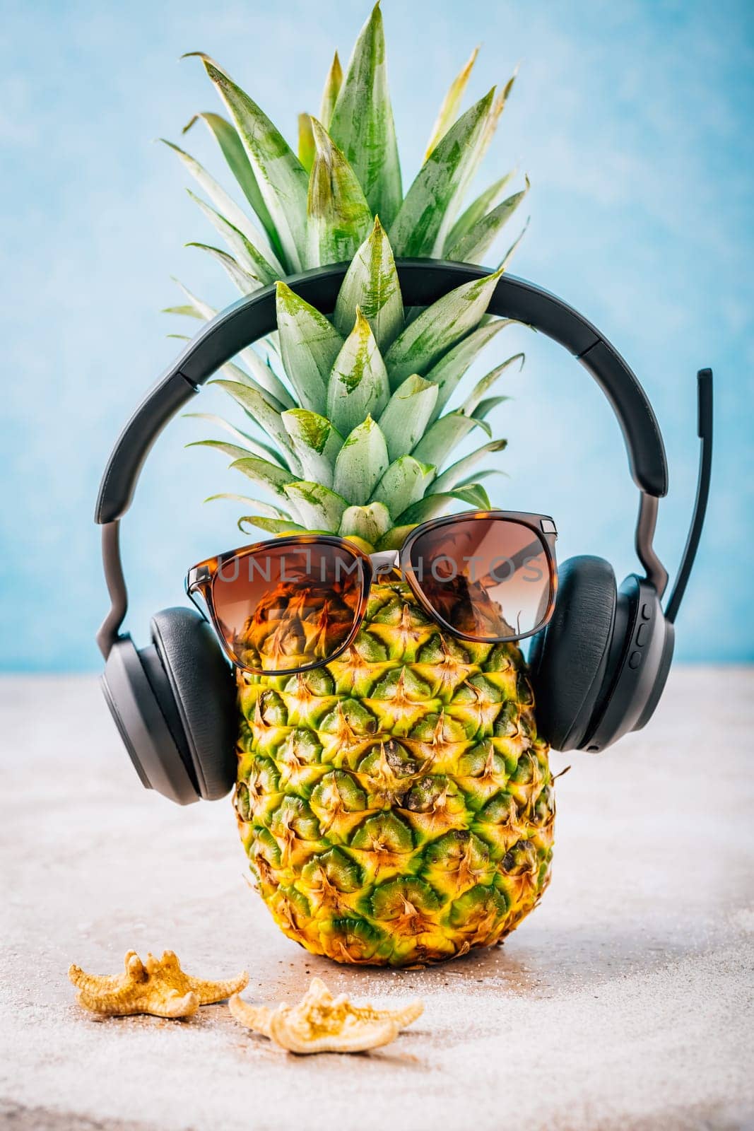 Summer concept - Pineapple hipster in sunglasses and headphones with melon and lemons, creative art fashionable vacation concept