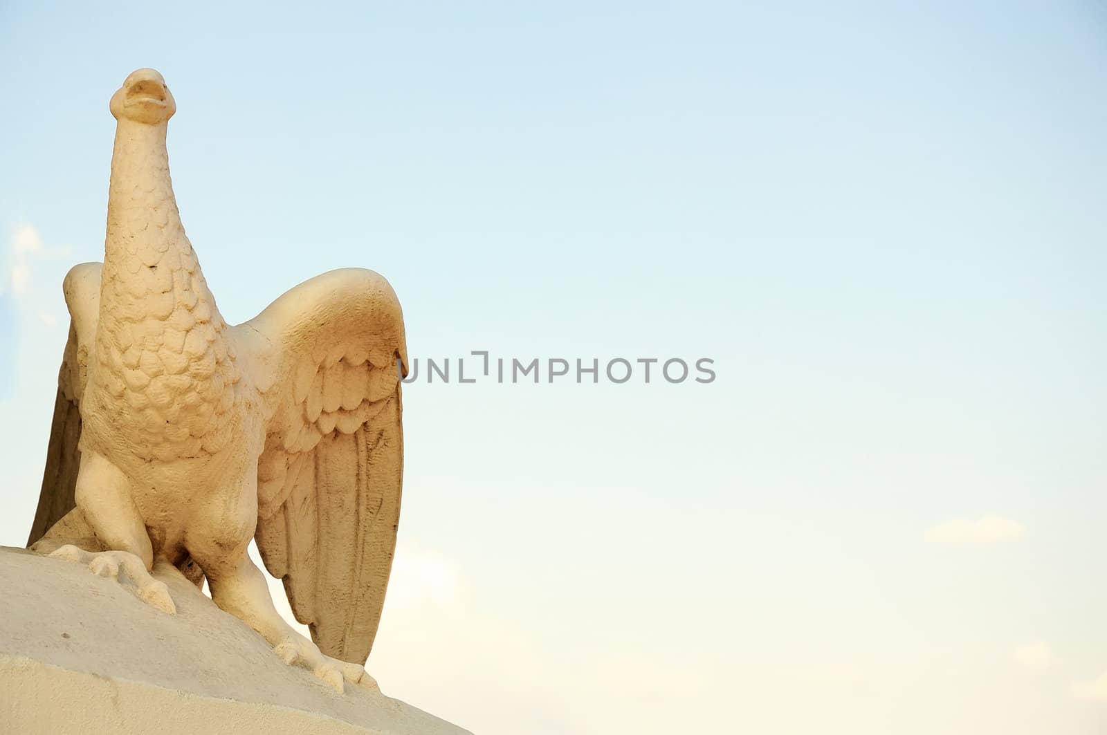 Statue fragment on an entrance in the Odessa opera theater - a bird the Phoenix, against the blue sky.