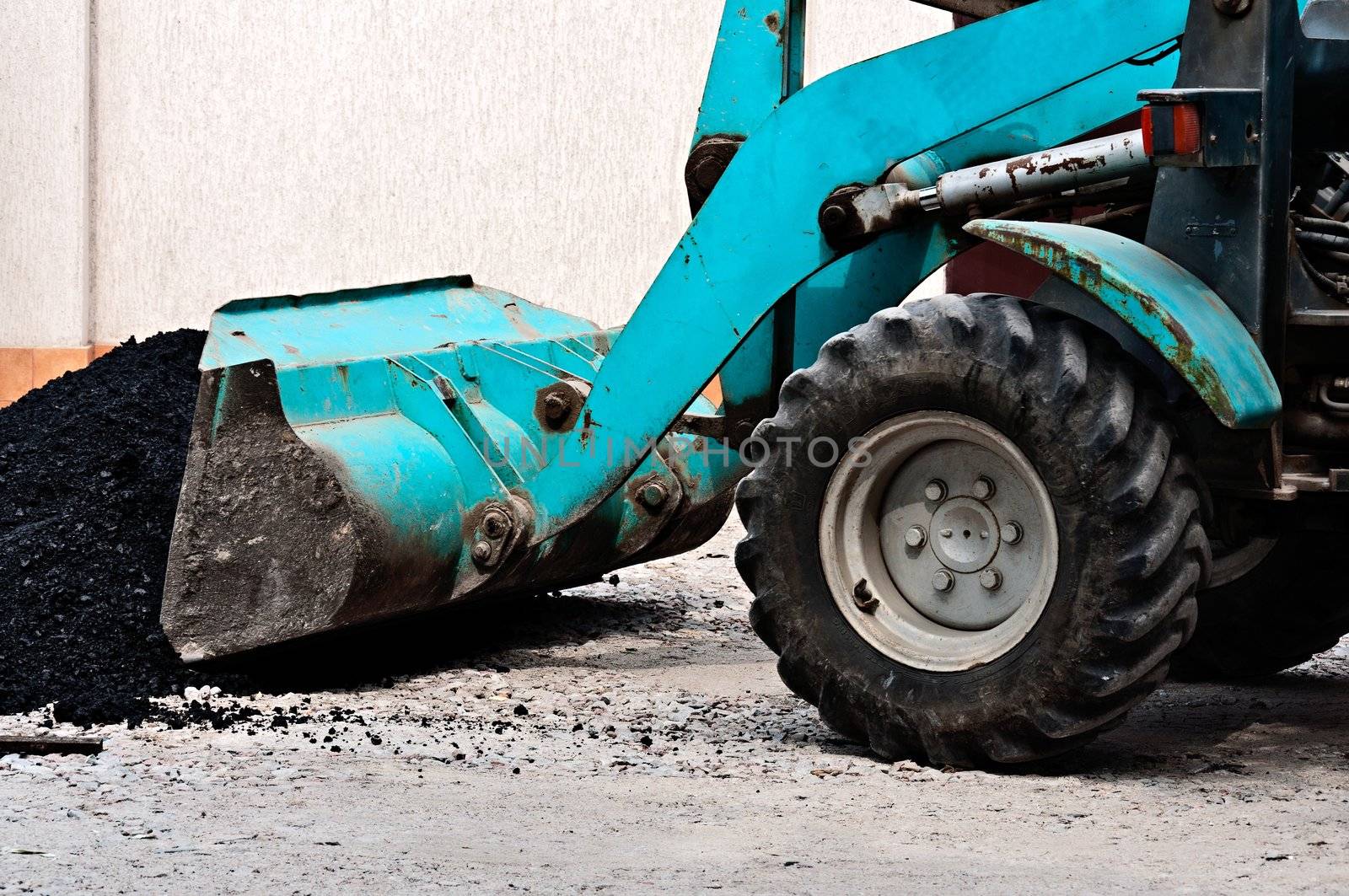 The wheel bulldozer works at asphalt laying.