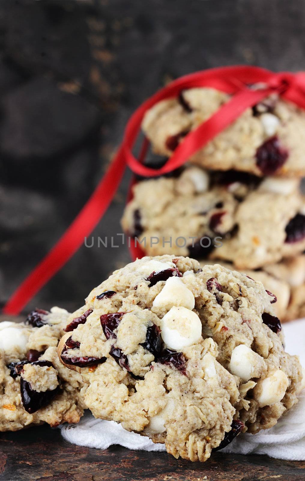 Cranberry, oats and white chocolate chip cookies over a rustic background.