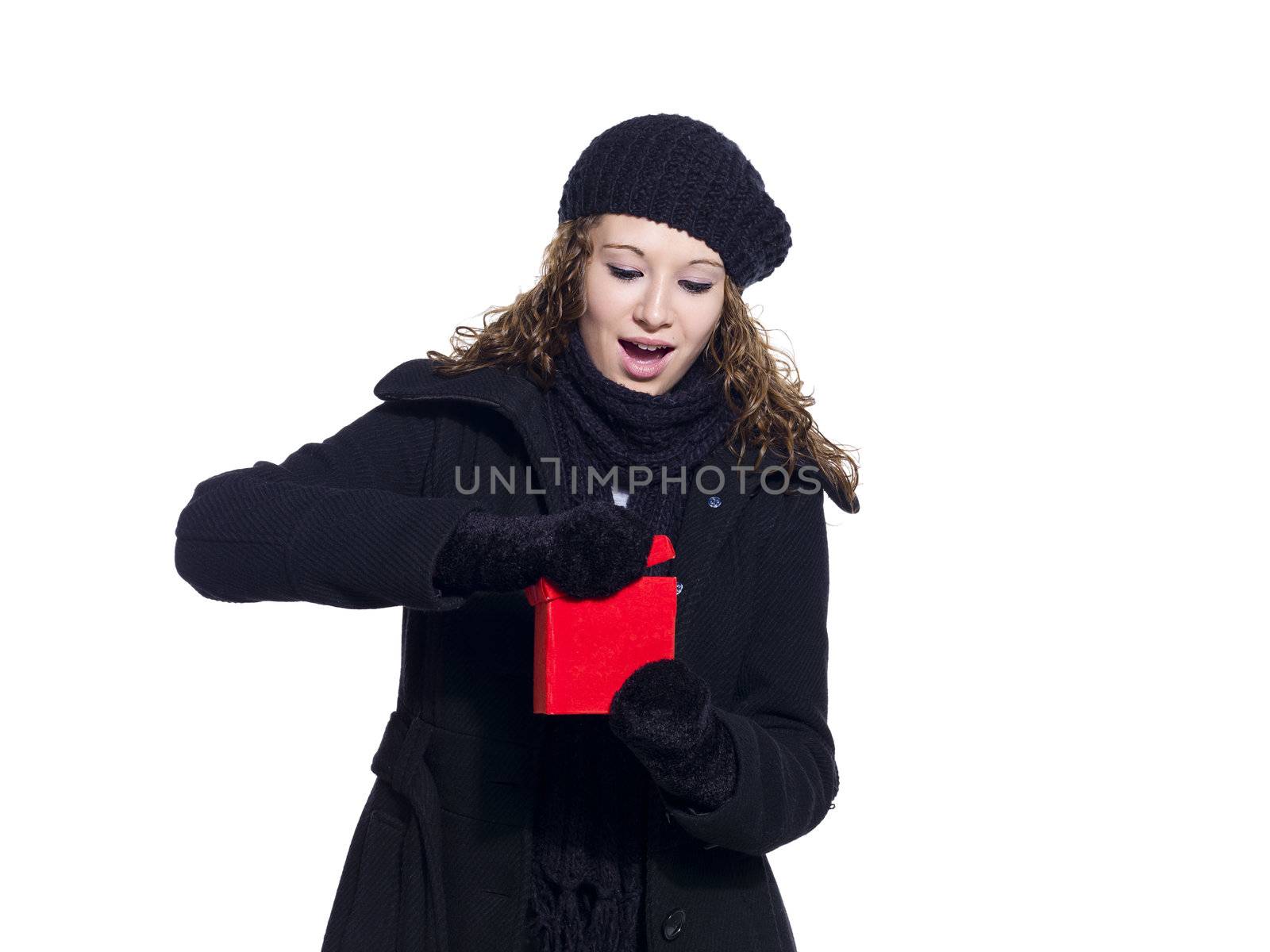 Woman in winter clothing opening her Christmas present against white background, Model: Brittany Beaudoin